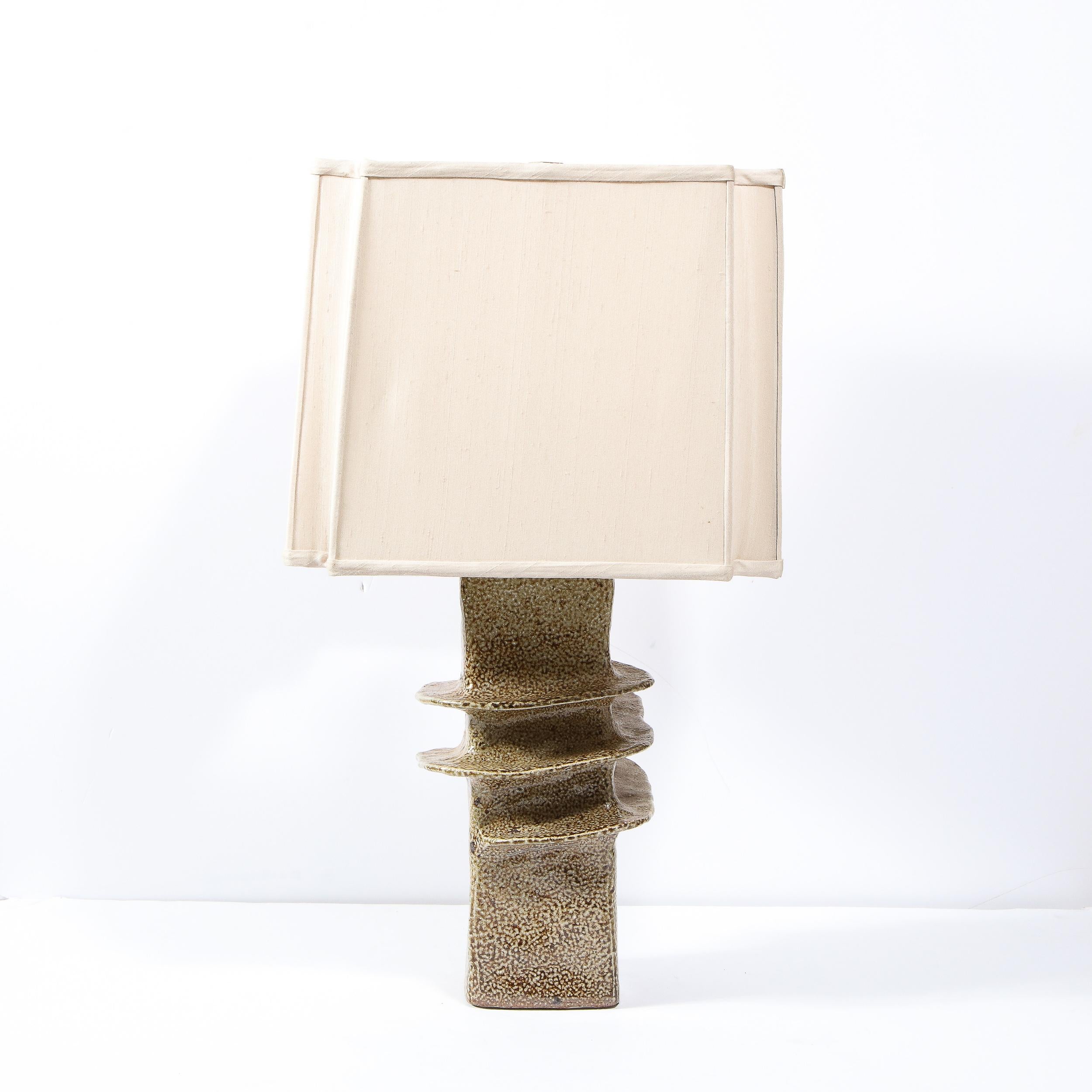 This exquisite glazed ceramic sculptural table lamp was realized in mid century France. It's earthy textural quality and hand shaped spiral configuration wrapping around a rectangular body creates a one of a kind unique design. With a new custom