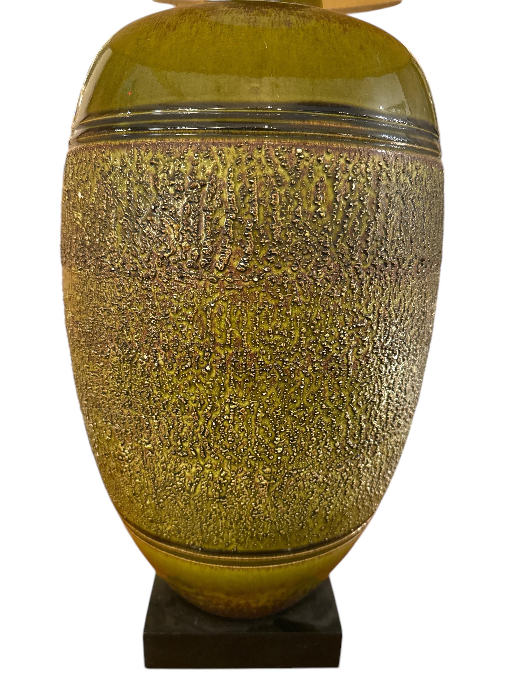 Apportez une touche de modernité du milieu du siècle à votre intérieur avec cette lampe de table en poterie émaillée du milieu du siècle. Avec ses lignes épurées, sa forme sculpturale et son riche socle en céramique émaillée, cette lampe reflète