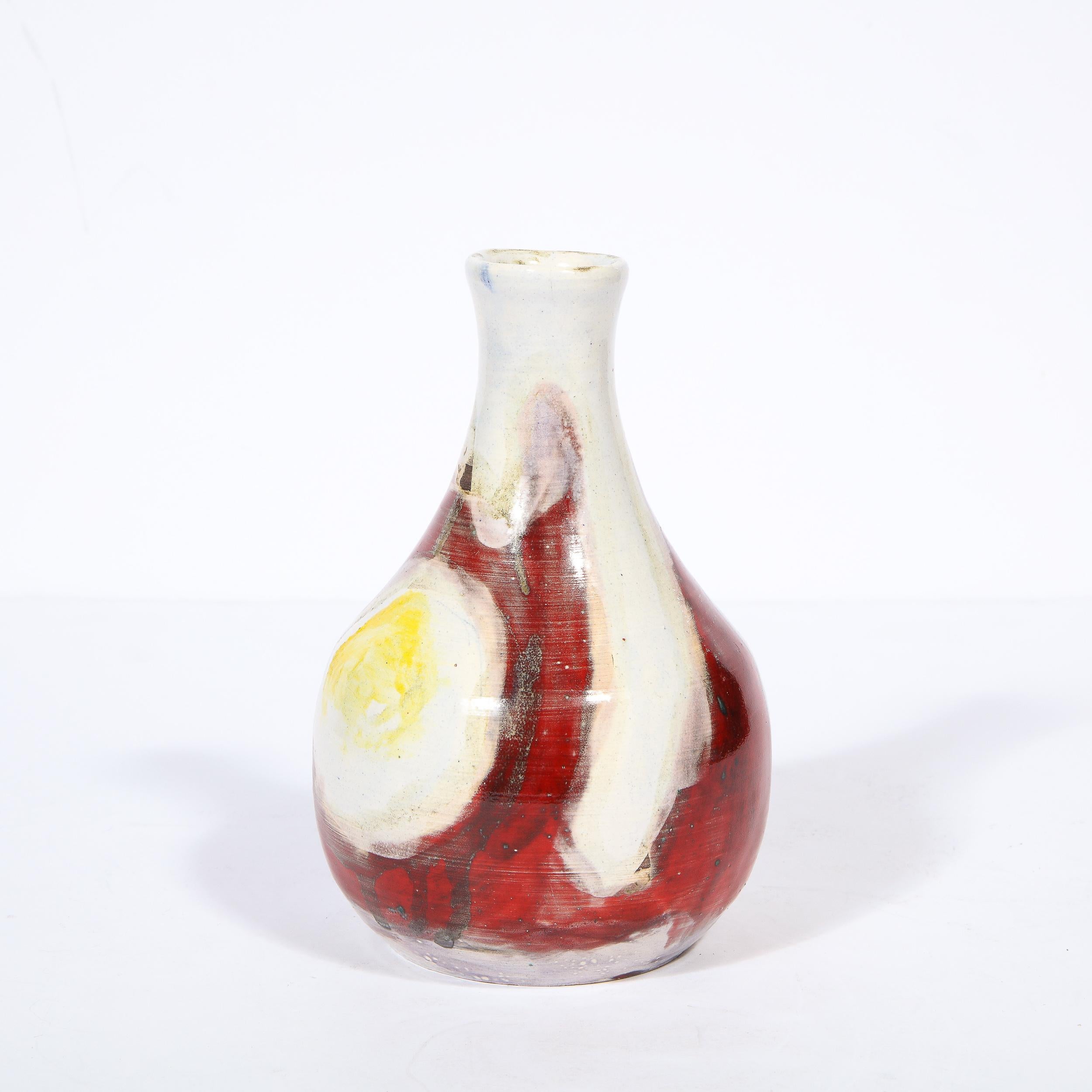 This stunning Mid Century Modern ceramic vase was realized by the esteemed artist Jean Mégard in France in 1953. It features a teardrop form with a bulbous base that tapers to an elongated neck. The handcrafted ceramic offers an expressionistic