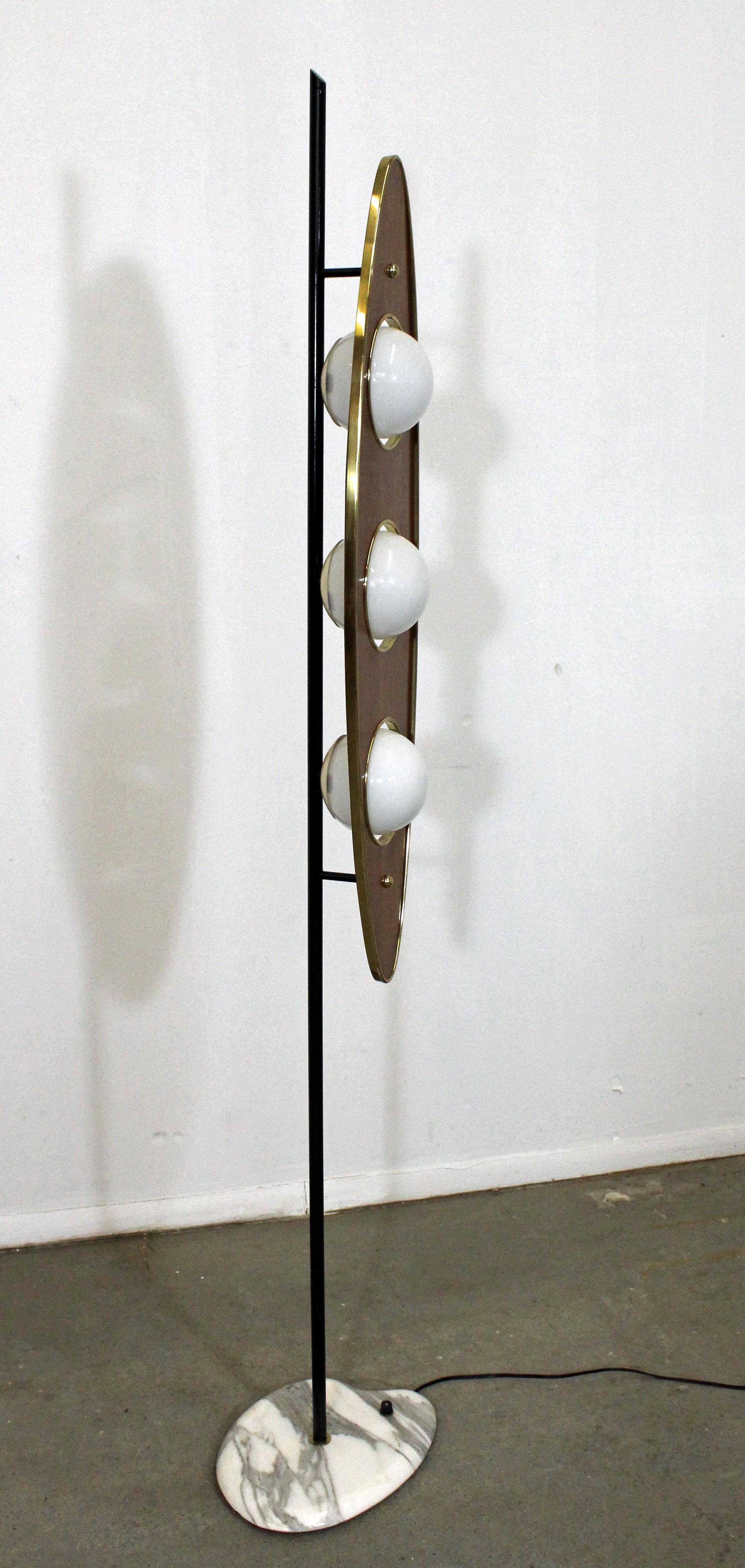 Offered is an awesomely unique Mid-Century Modern floor lamp, attributed to Goffredo Reggiani. Features a marble base with a walnut and brass paddle-shade with three bulbs. The light switch is on the base. It has been tested and is in excellent