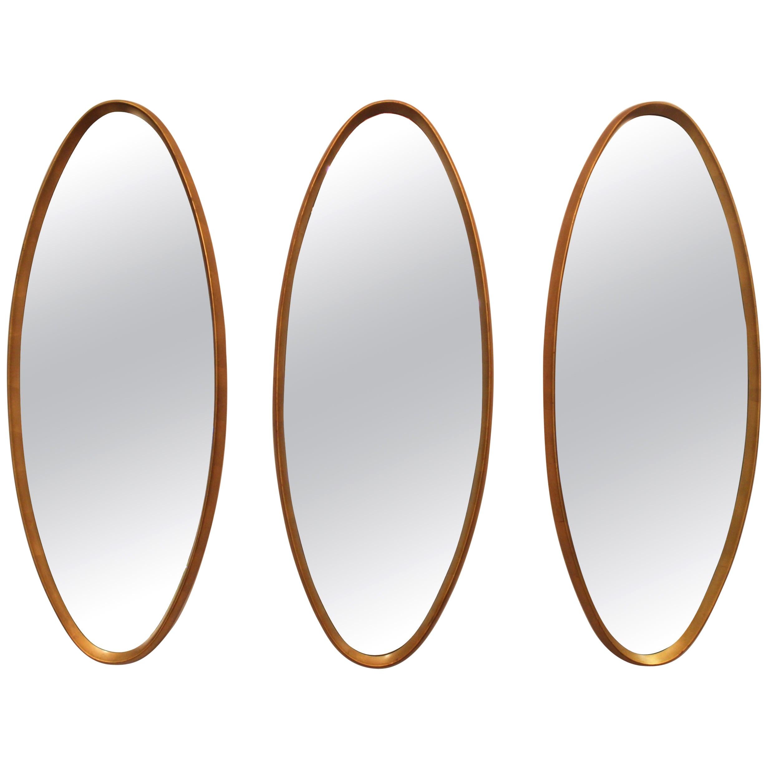 Stunning set of three 1960s Mid-Century Modern gold leaf oval mirrors, in the style of La Barge.