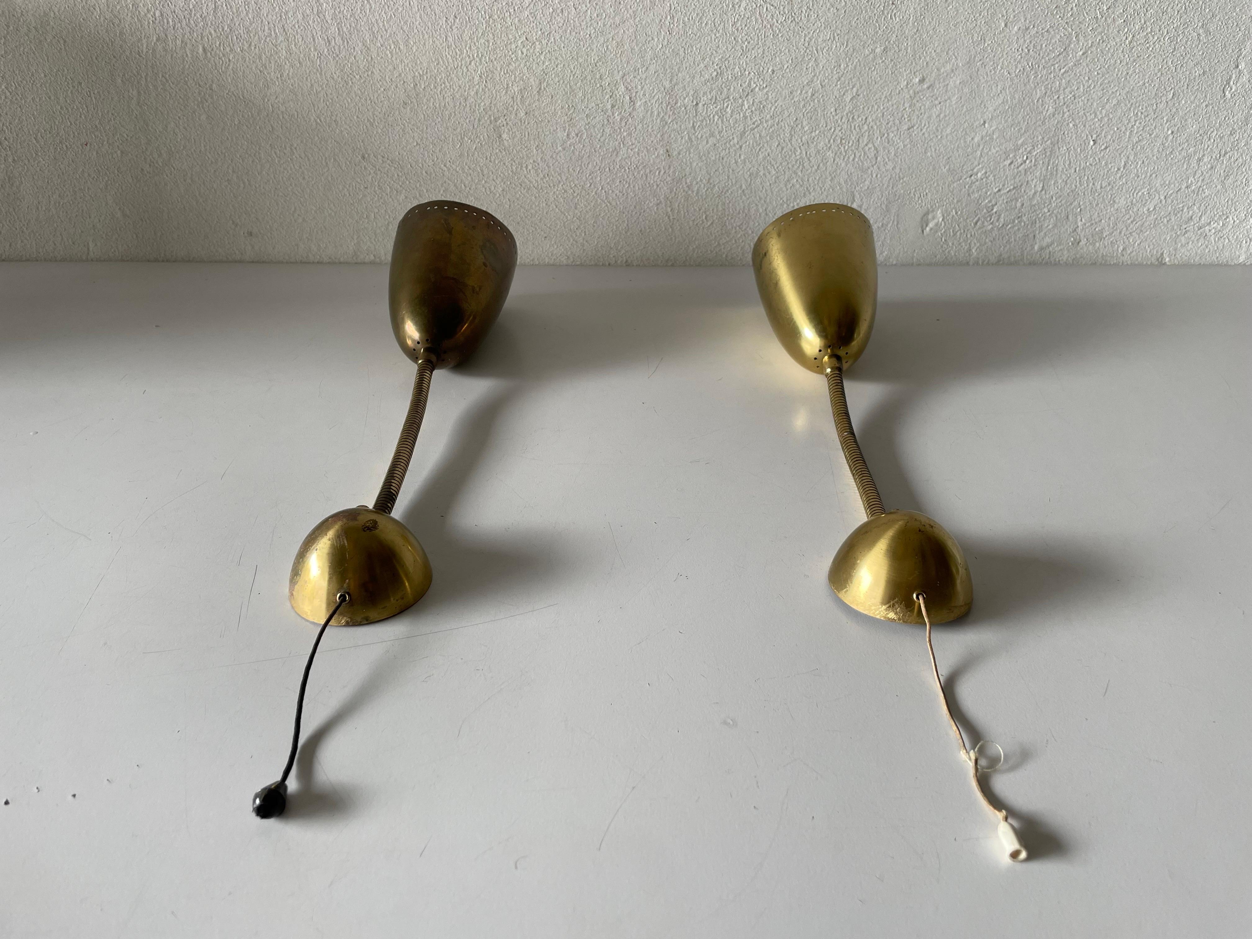 Mid-Century Modern gold metal pair of sconces, 1950s, Germany.

Very elegant and Minimalist wall lamps.
Lamp is in very good condition.

These lamps works with E27 standard light bulbs. 
Wired and suitable to use in all countries. (110-220