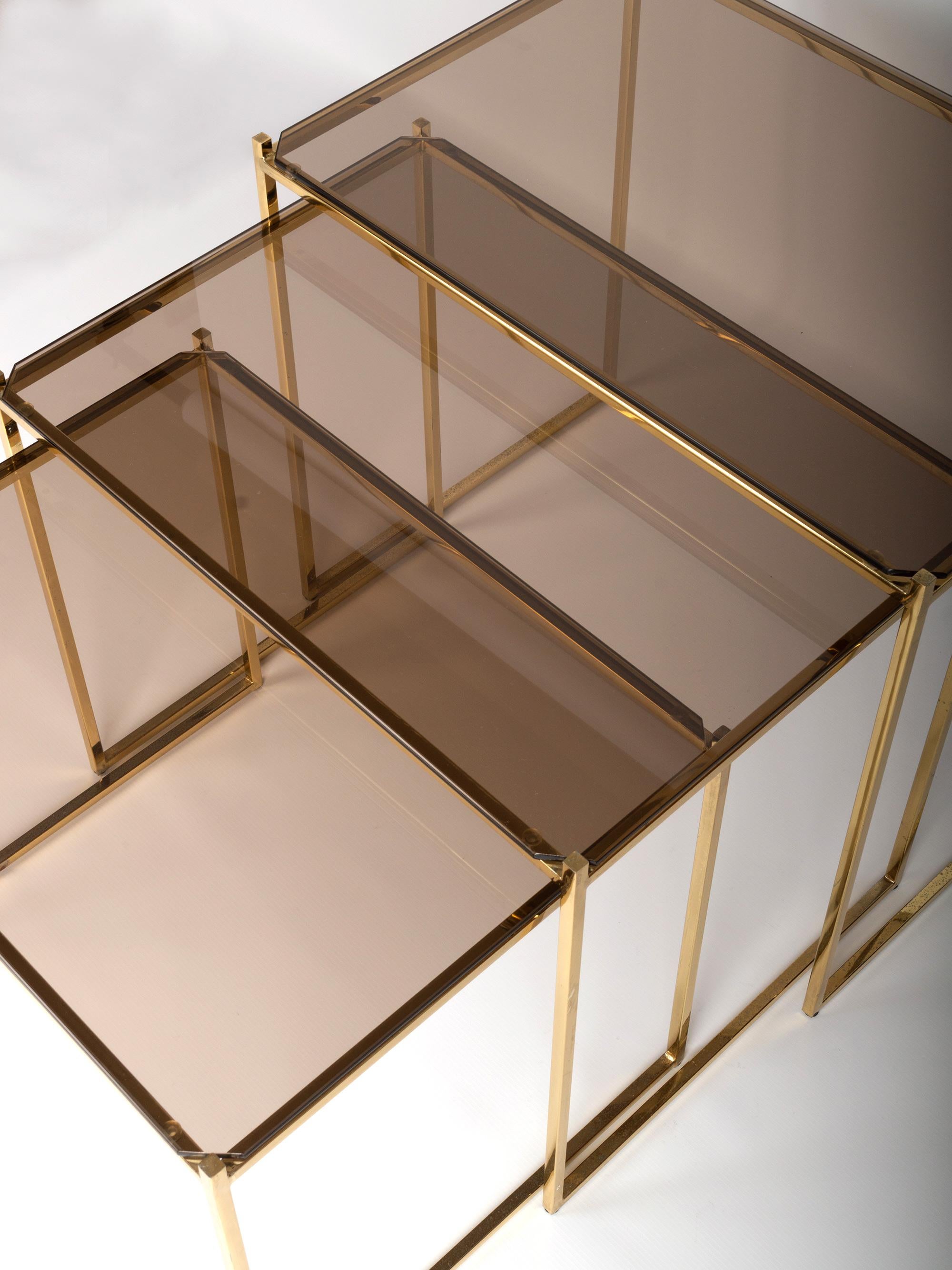 Mid-Century Modern gold-plated nesting side tables 
Attributed to Milo Baughman, USA, circa 1970.
Gold-plated gilded metal nest of three tables, inset with smoked glass.
Very good vintage condition commensurate of age.

Dimensions:
H 46 x W 55