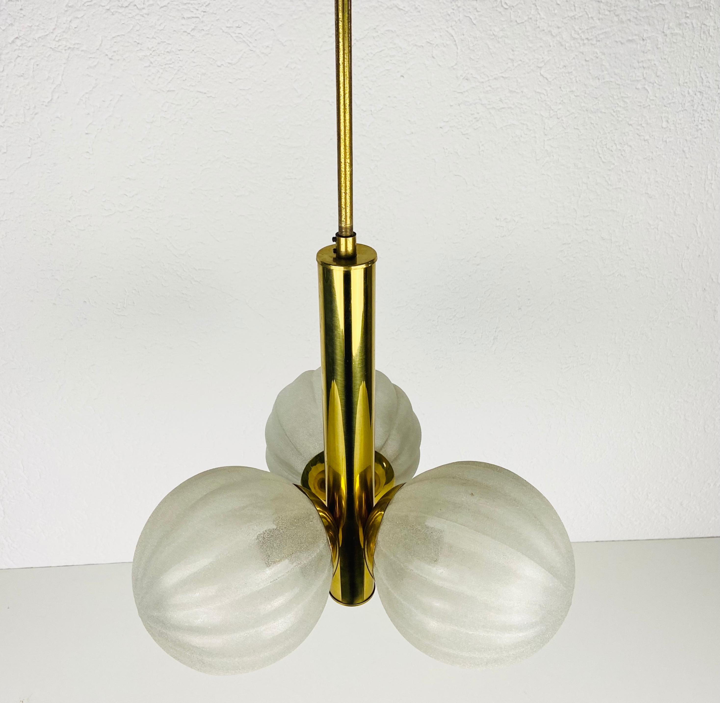 Ein Kaiser-Kronleuchter aus der Mitte des Jahrhunderts, hergestellt in Deutschland in den 1960er Jahren. Sie fasziniert mit ihrem Space Age Design und den drei Opalglaskugeln. Das Gehäuse der Leuchte ist aus poliertem Messing, einschließlich der