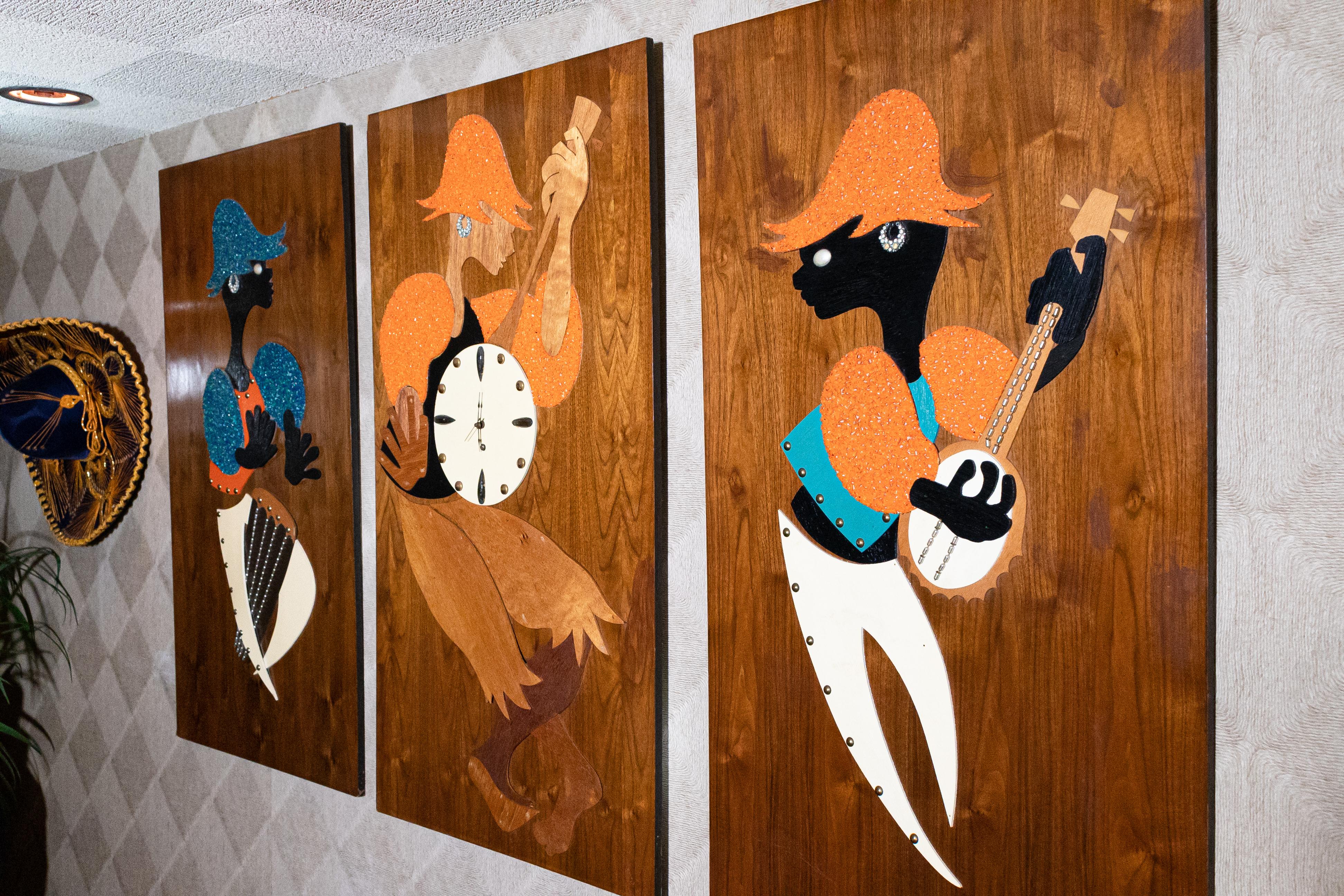 A very fun mixed media triptych art piece with center clock on wood panels. The piece depicts 3 musicians playing two stringed instruments and a drum. The center piece instrument is the clock. In very good vintage condition. This piece measures 24in