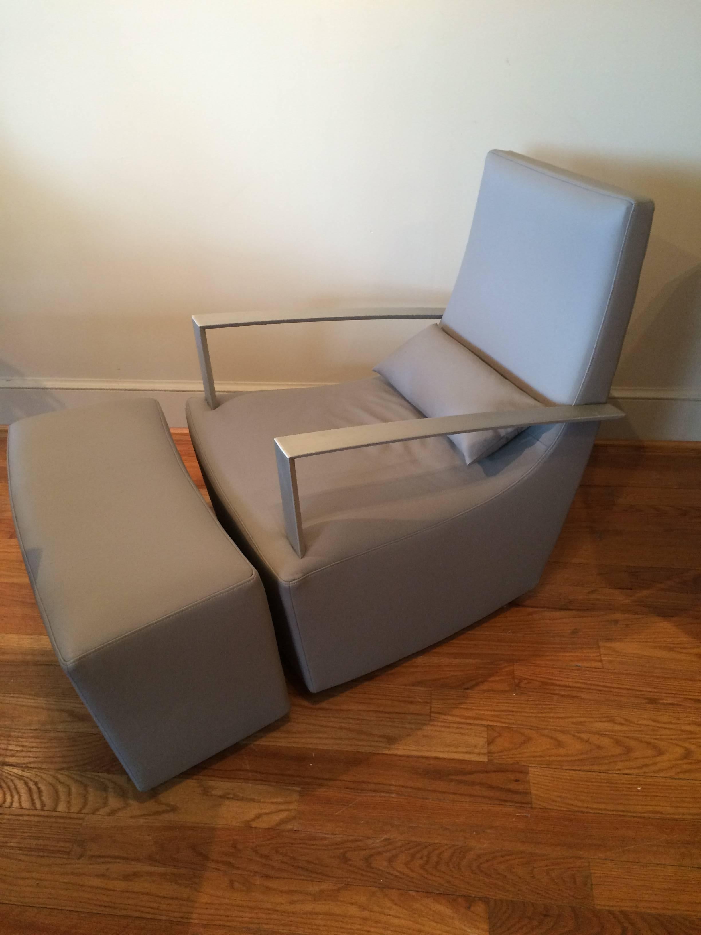 The Mid-Century Modern gray leather armchair and ottoman set with Brushed Steel Arms is a great example of mid-century modern design. The recently reupholstered modern gray leather combined with the sophistication of brushed steel arms gives this