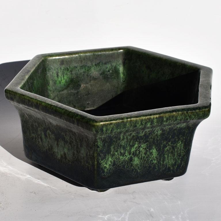 Lovely bright green and black glazed planter by Haeger. This ceramic octagonal low planter is a fantastic midcentury addition to a patio or living room. With a footed bottom the piece is glazed in a black shiny glazed at bottom, and transitions