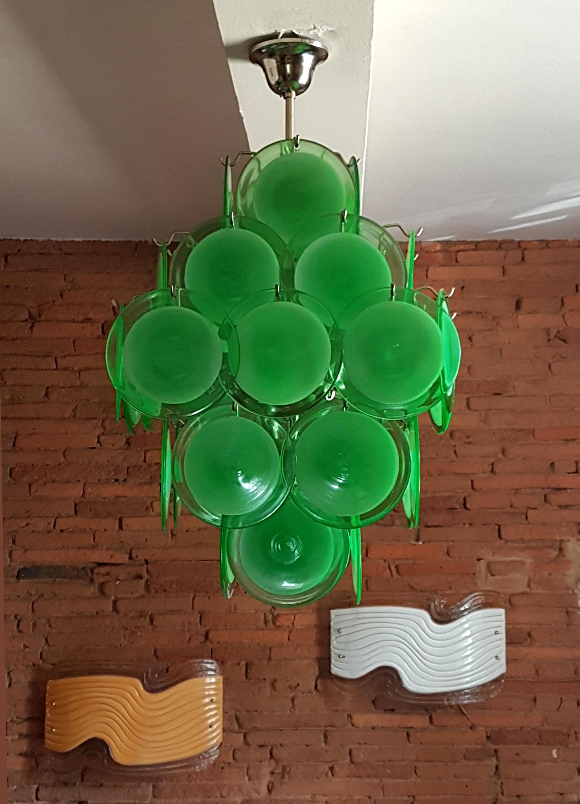 Green Mid-Century Modern Murano glass and chrome frame disc chandelier, by Vistosi.
Italy, 1970s.
Pyramidal shape. 
Each hand blown green disc is translucent in the center, and transparent on the edge.
The Mid-Century Modern chandelier has 5