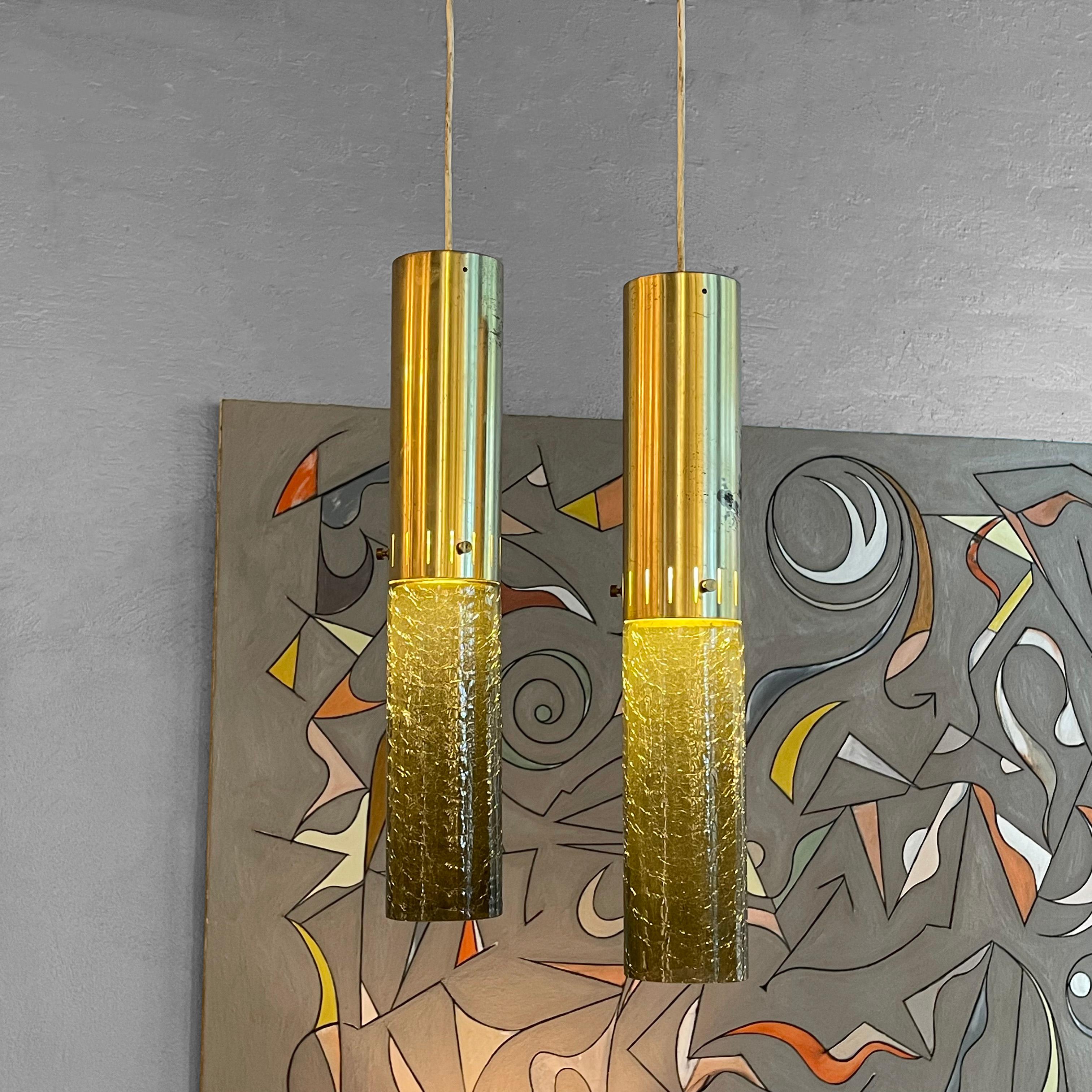 Pair of Mid-Century Modern pendants feature textured, green glass cylinders with perforated anodized aluminum tops and matching canopies. The pendants hang at 42 inches overall.
