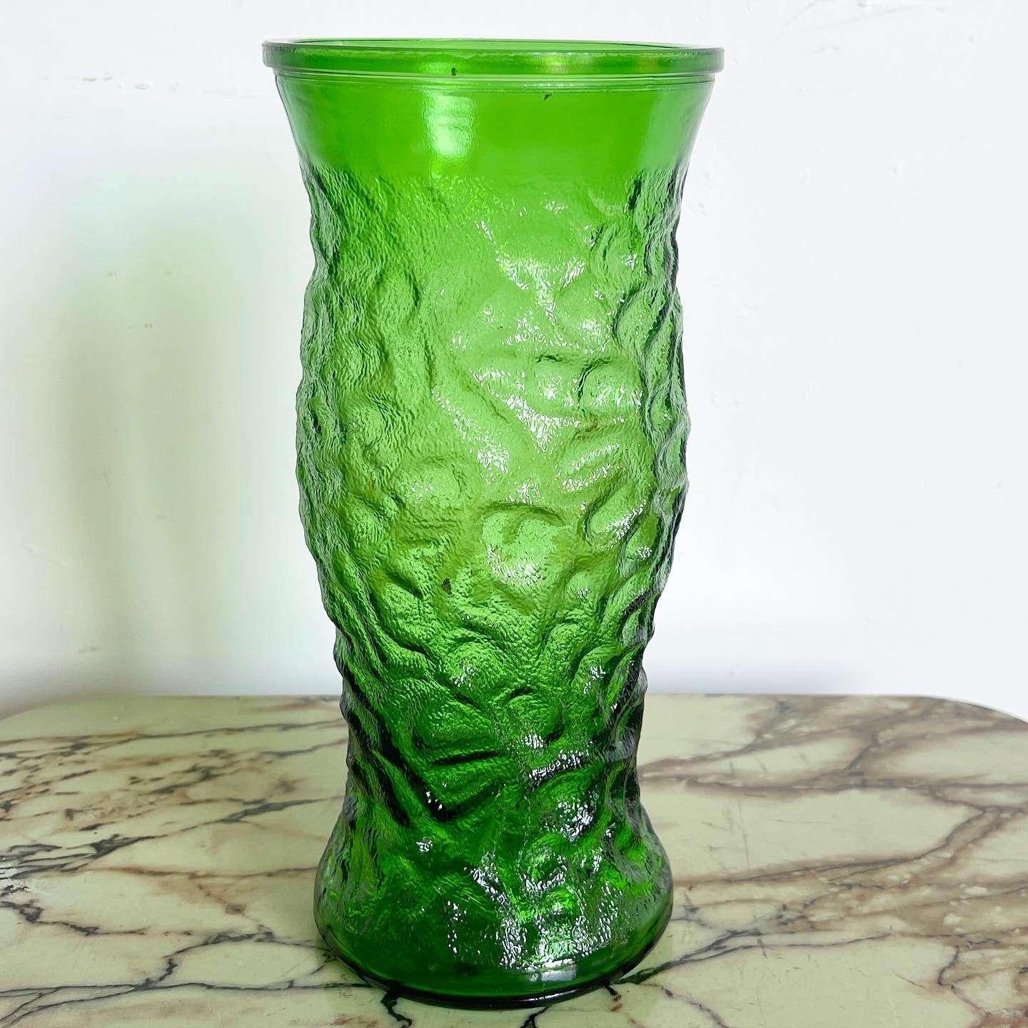 Add a touch of vintage charm with this exceptional mid-century modern green glass vase by Hoosier. Crafted with meticulous attention to detail, this vase features a textured green body, exuding a unique and captivating appeal that effortlessly