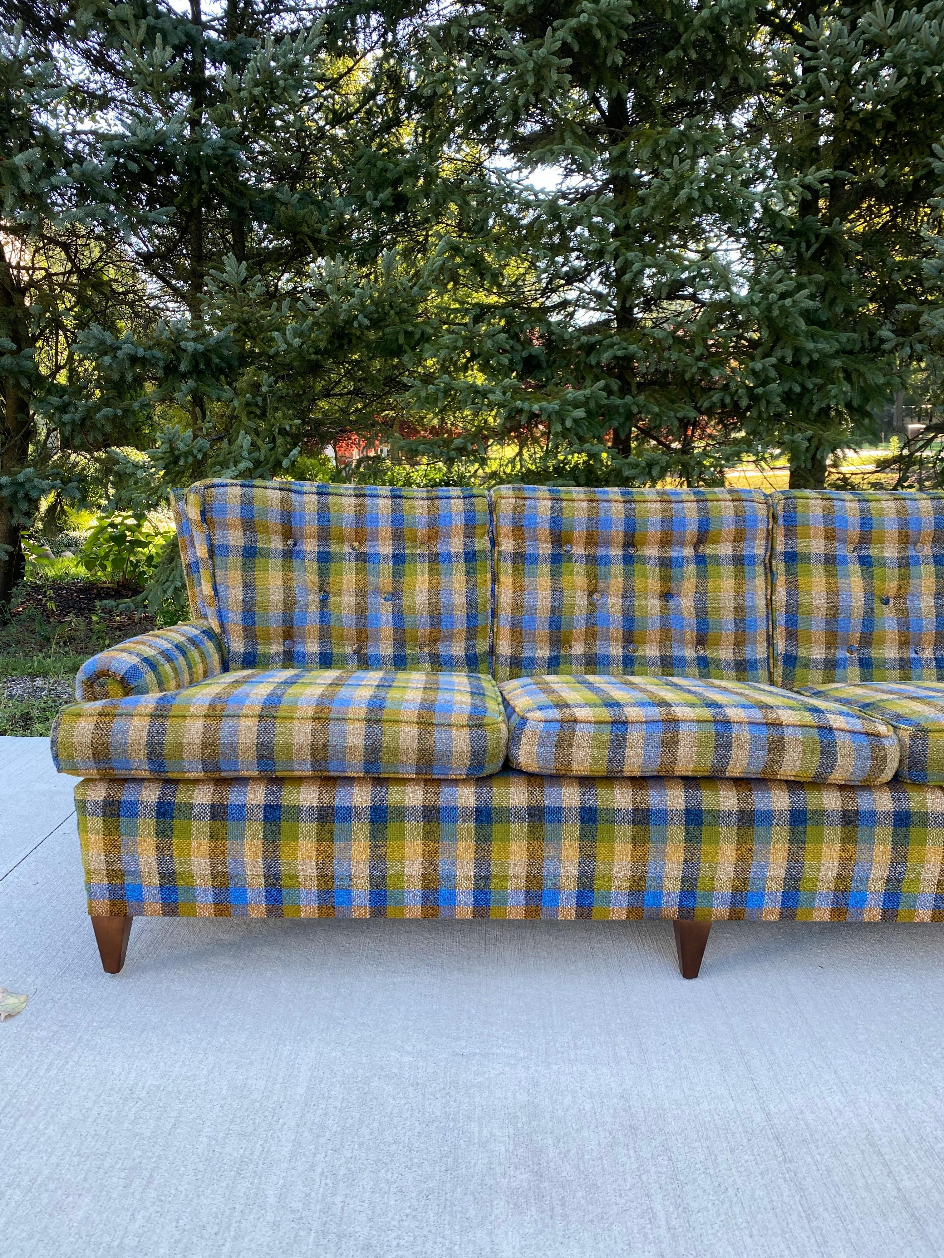 A gorgeous Mid-Century Modern green plaid 3-seater sofa in an amazing condition. Truly a statement piece with its fabric, tufted back cushions, curved back and Mid-Century Modern legs. Make this sofa a statement piece in your home!