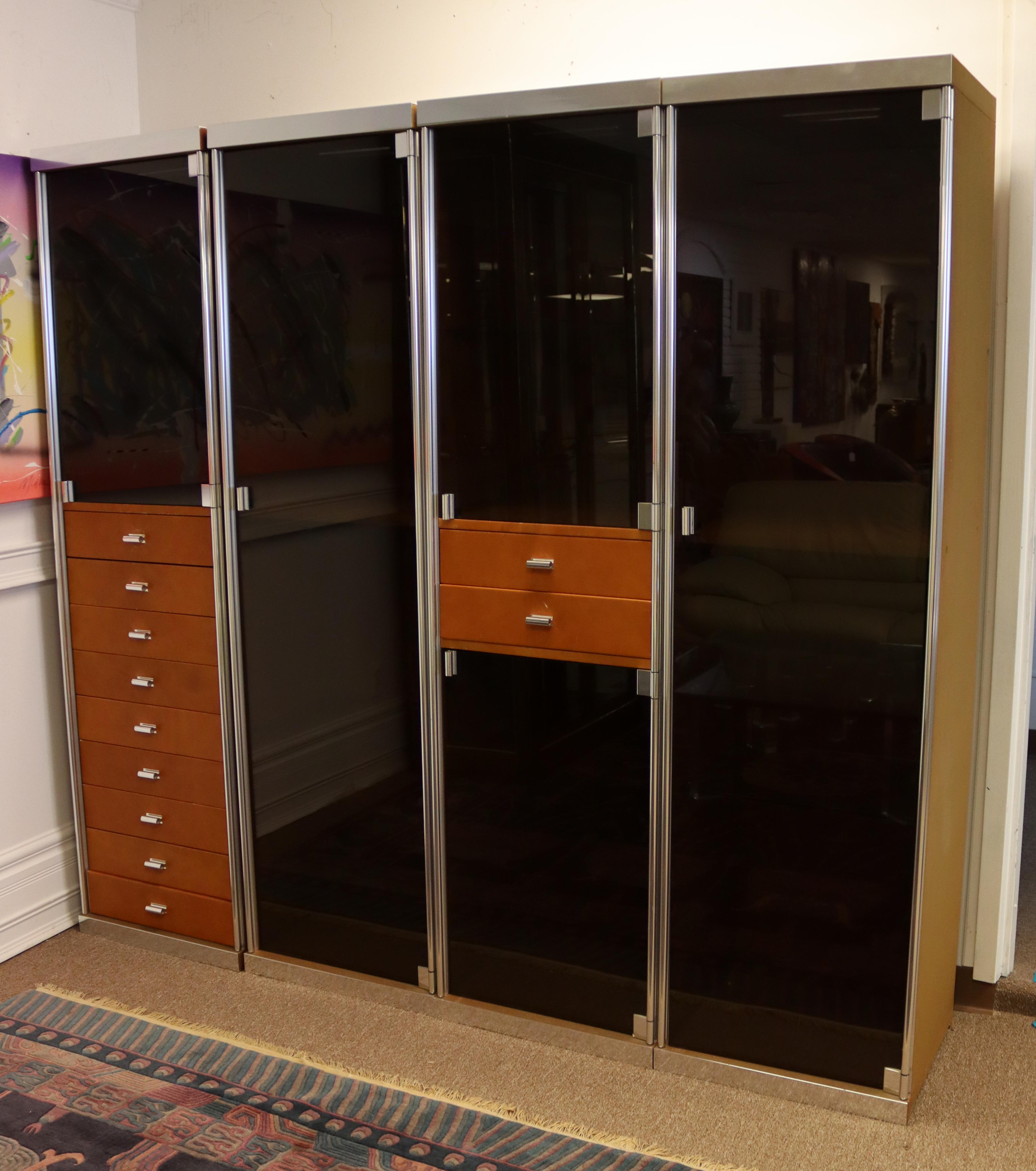 For your consideration is a stupendous set of four cabinets or wardrobes, with smoked glass doors and chrome and leather accents, by Guido Faleschini for Pace, circa the 1970s. In very good vintage condition. The dimensions of each are 20