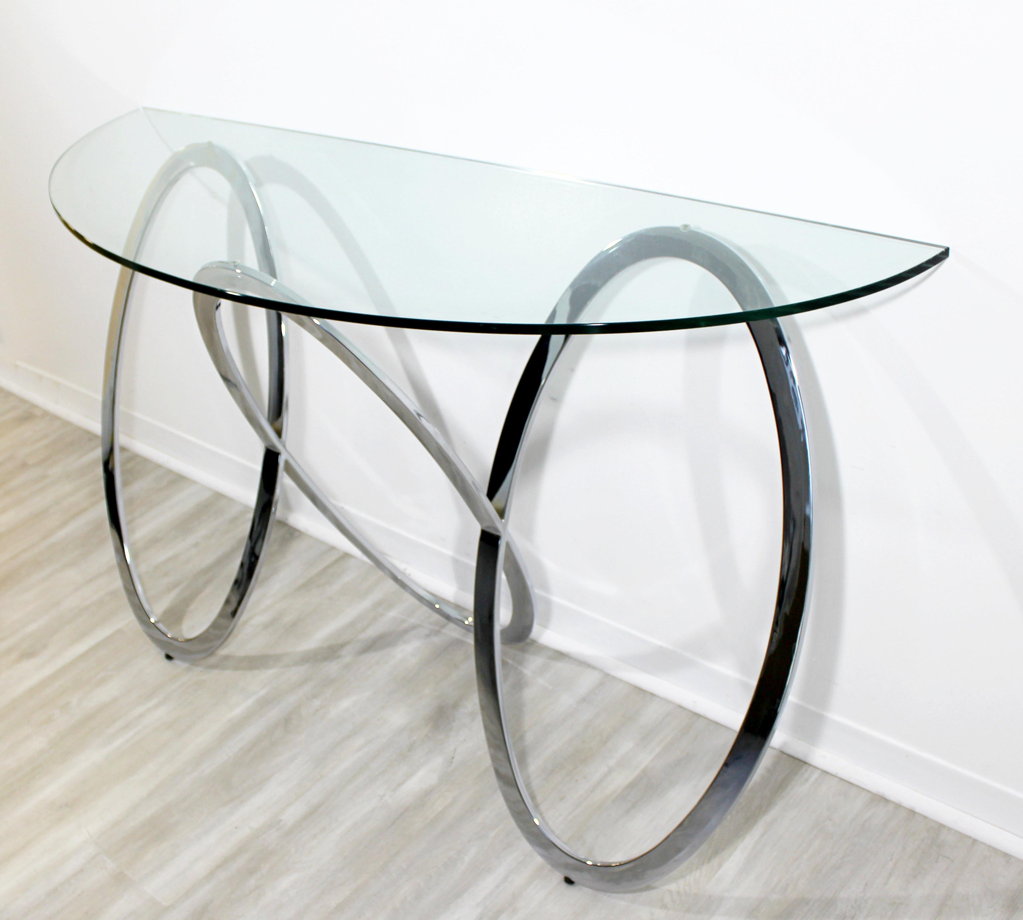 For your consideration is a unique, half-moon console table, made of chrome and glass, by Milo Baughman, circa 1970s. Base is in excellent condition, but the glass has a large chip, close up in photos. The dimensions are 56