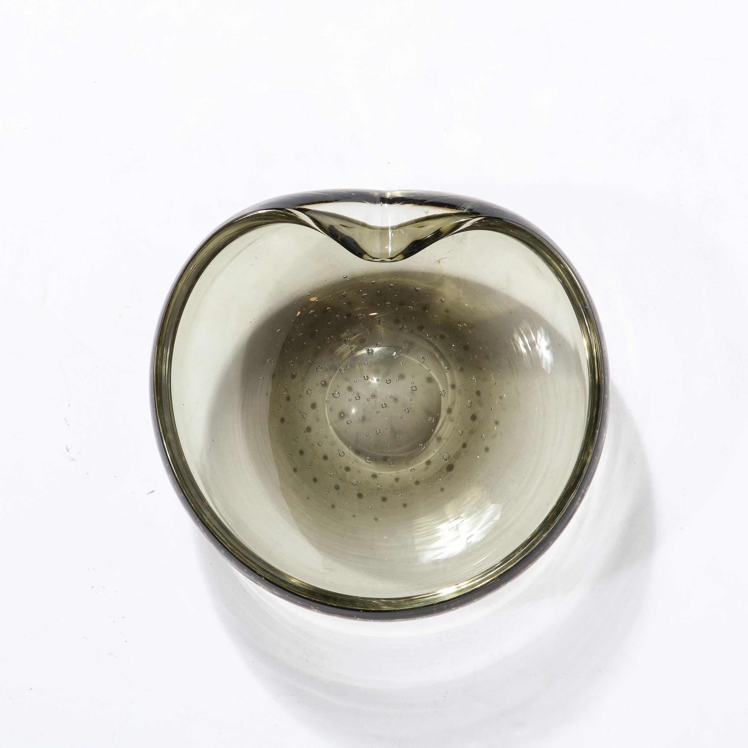 Diese elegante dekorative Schale aus der Mitte des Jahrhunderts wurde in Murano, Italien, hergestellt - der Insel vor der Küste Venedigs, die seit Jahrhunderten für ihre hervorragende Glasproduktion bekannt ist - um 1970. Der kreisförmige Körper mit