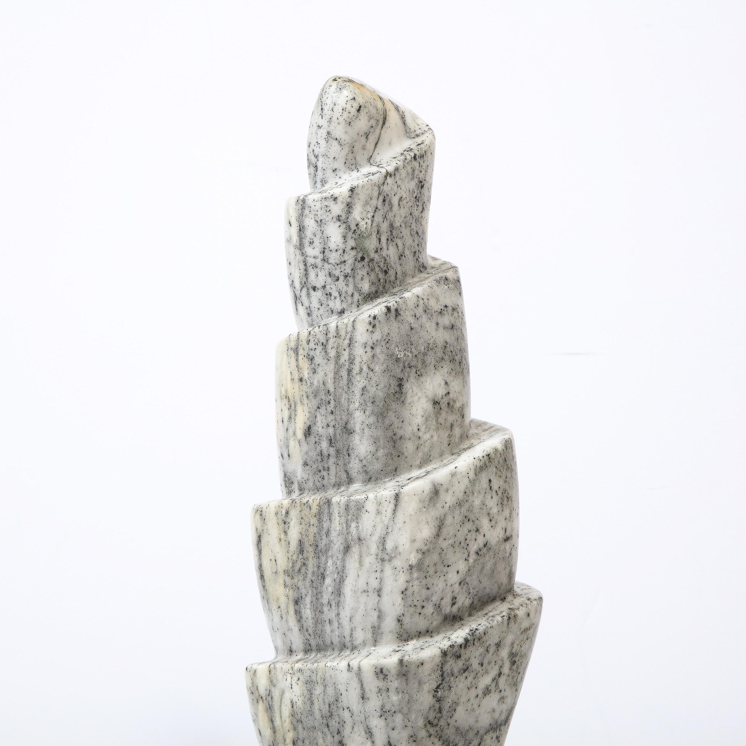 This dynamic and refined Mid-Century Modern sculpture was realized in the United States, circa 1970. It features a totem hand-carved form consisting of various tiers of grisaille granite- replete with a rich and organic innate texture. The granite