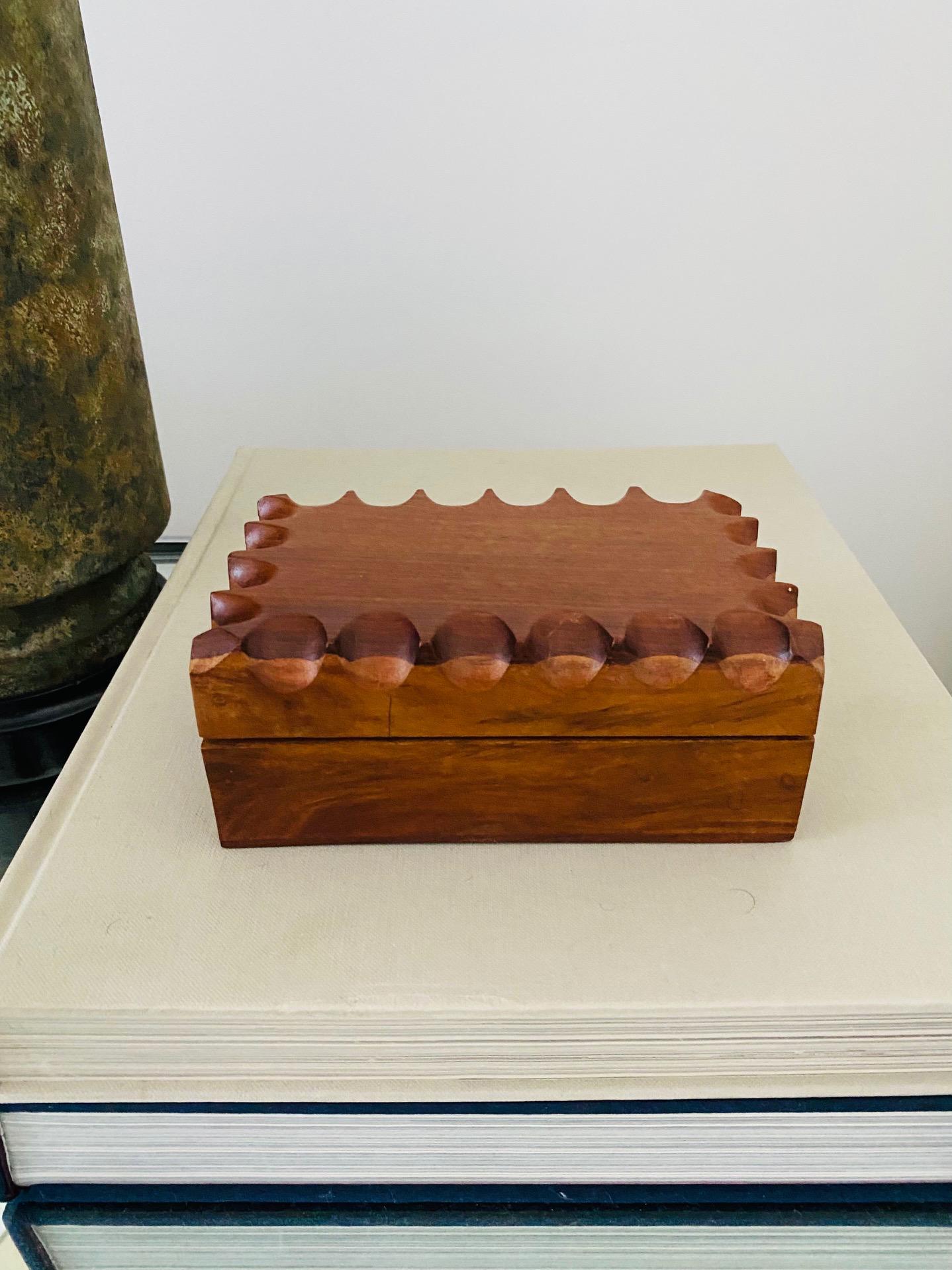 Vintage Scandinavian Modern mixed wood box in walnut and teak. The decorative box features hand carved scalloped notches along the top borders, creating a geometric design. The two-tone box features a darker walnut wood top over a slightly lighter