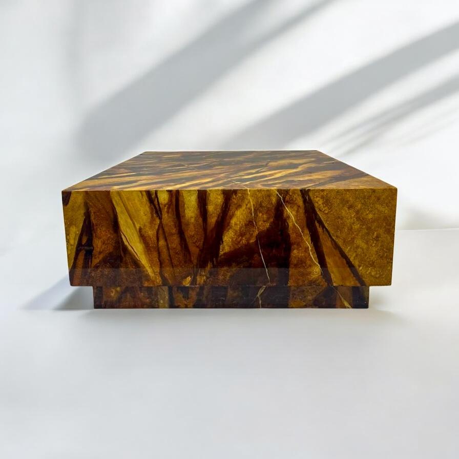 I love the finish on this mid-century modern coffee table! It is a large scale floating square with a faux tiger’s eye finish in golds and browns. The plinth is finished in the same finish. It rests on castors. It is unsigned. 