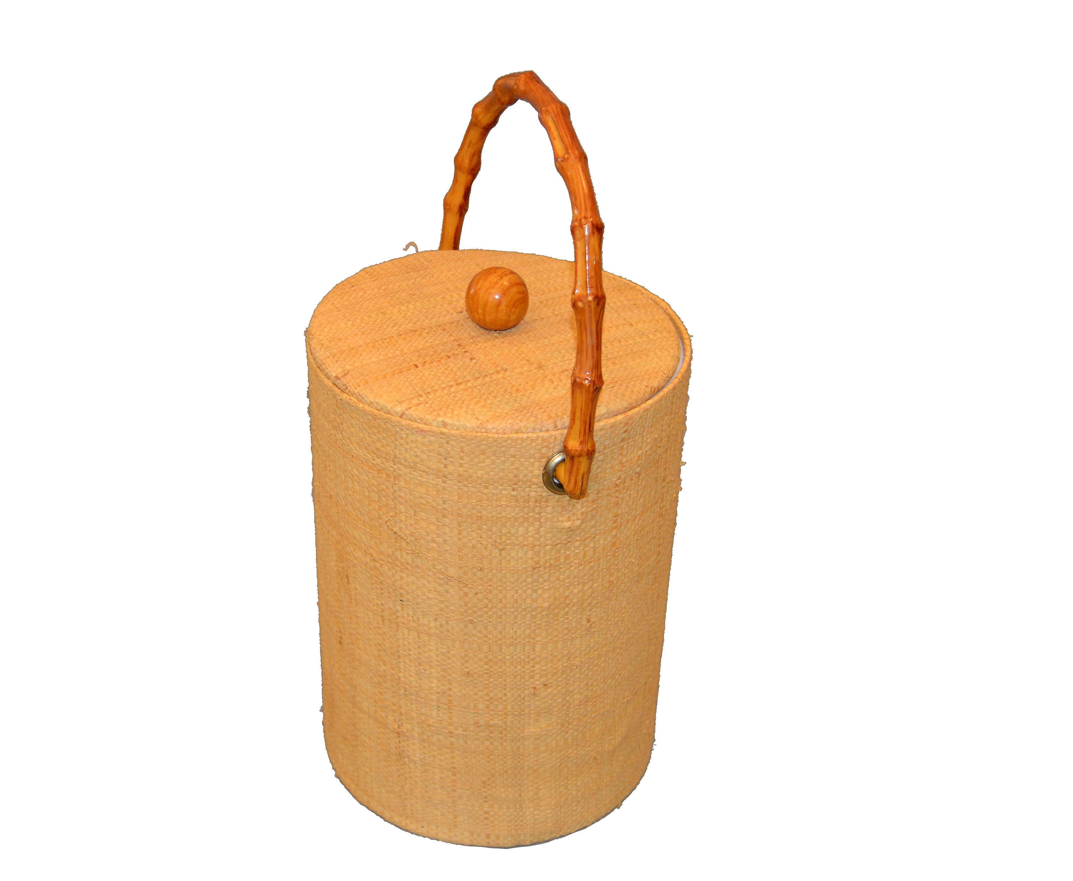 Mid-Century Modern insulated American made ice bucket with lid. 
It is made with elegant woven cane wrapping bands and has an insulated wall and comes with a fitting lid. The handle and knob are made out of Bamboo.
It is perfect for cooling wine,