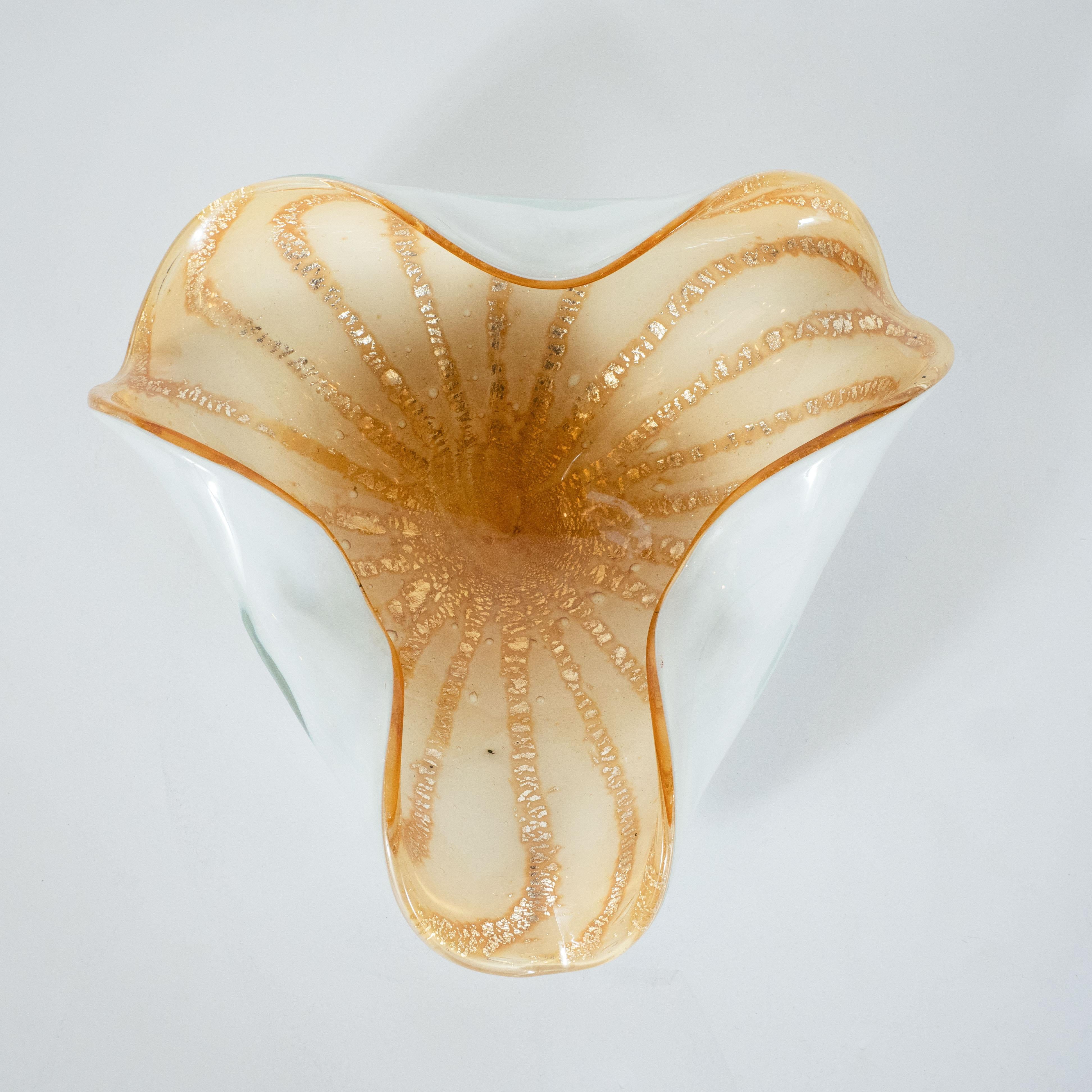 This dynamic Mid-Century Modern bowl was hand blown on the fabled island of Murano, Italy, off the coast of Venice renowned for centuries for its superlative glass production. This piece features a white exterior with flowing and sinuous curves