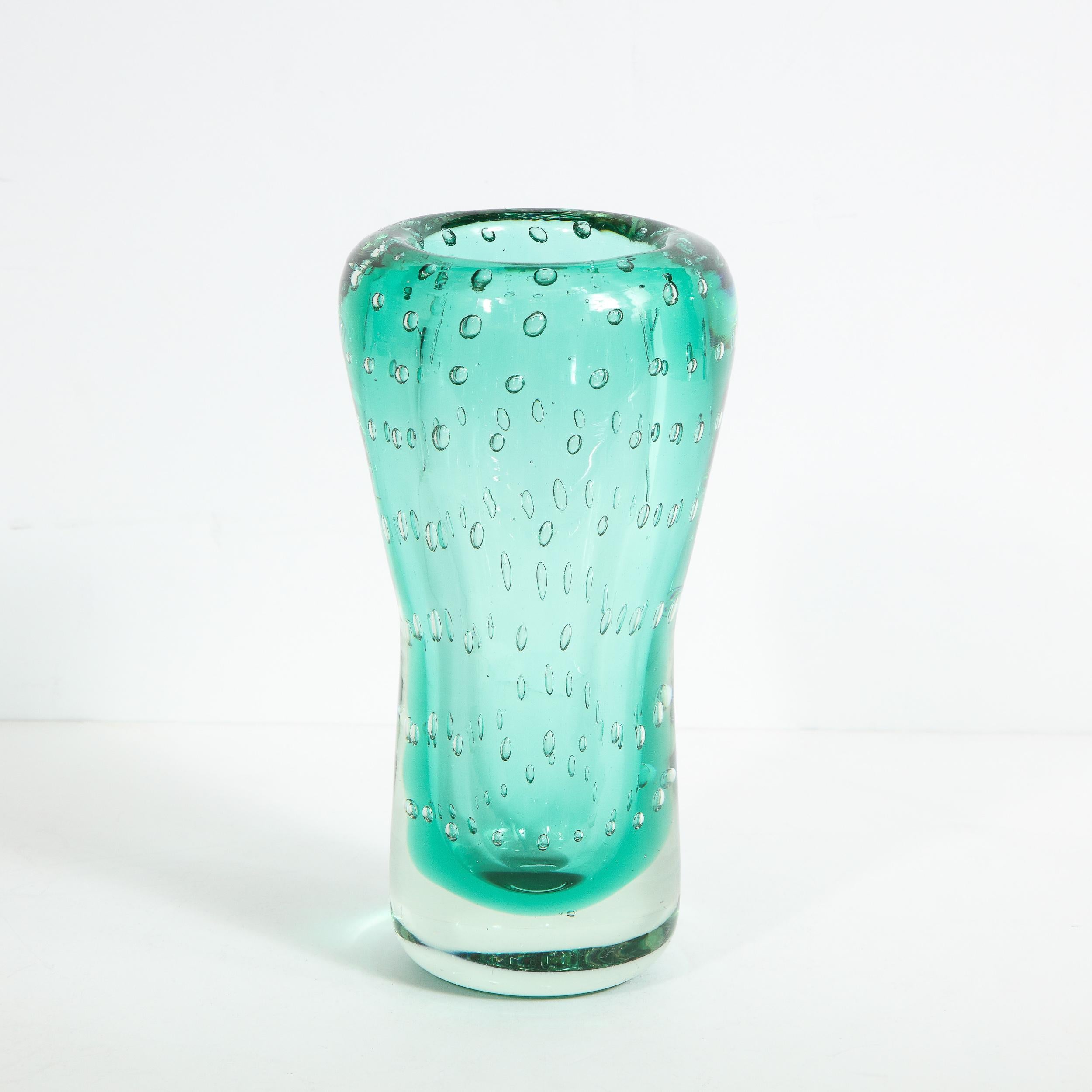 Questo elegante vaso Mid-Century Modern è stato realizzato a Murano, in Italia, l'isola al largo della costa di Venezia rinomata da secoli per la sua superlativa produzione di vetro, intorno al 1960. Presenta un corpo cilindrico che si assottiglia
