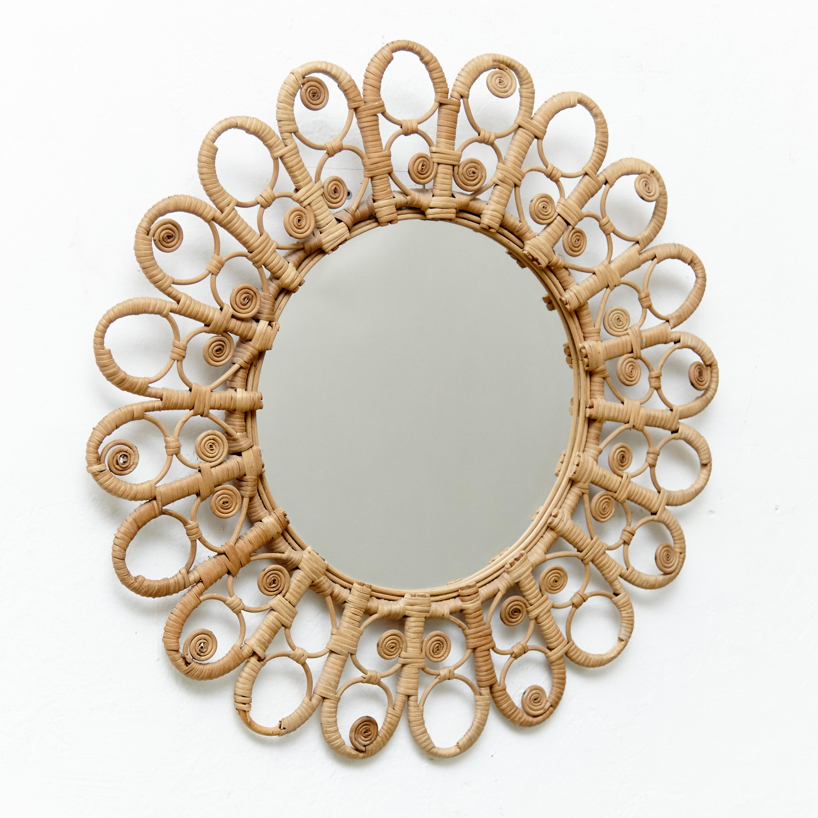 Mid-Century Modern handcrafted rattan peacock mirror, circa 1960
Traditionally manufactured in France with decorative spit curls.
By unknown designer.

In original condition with minor wear consistent of age and use, preserving a beautiful