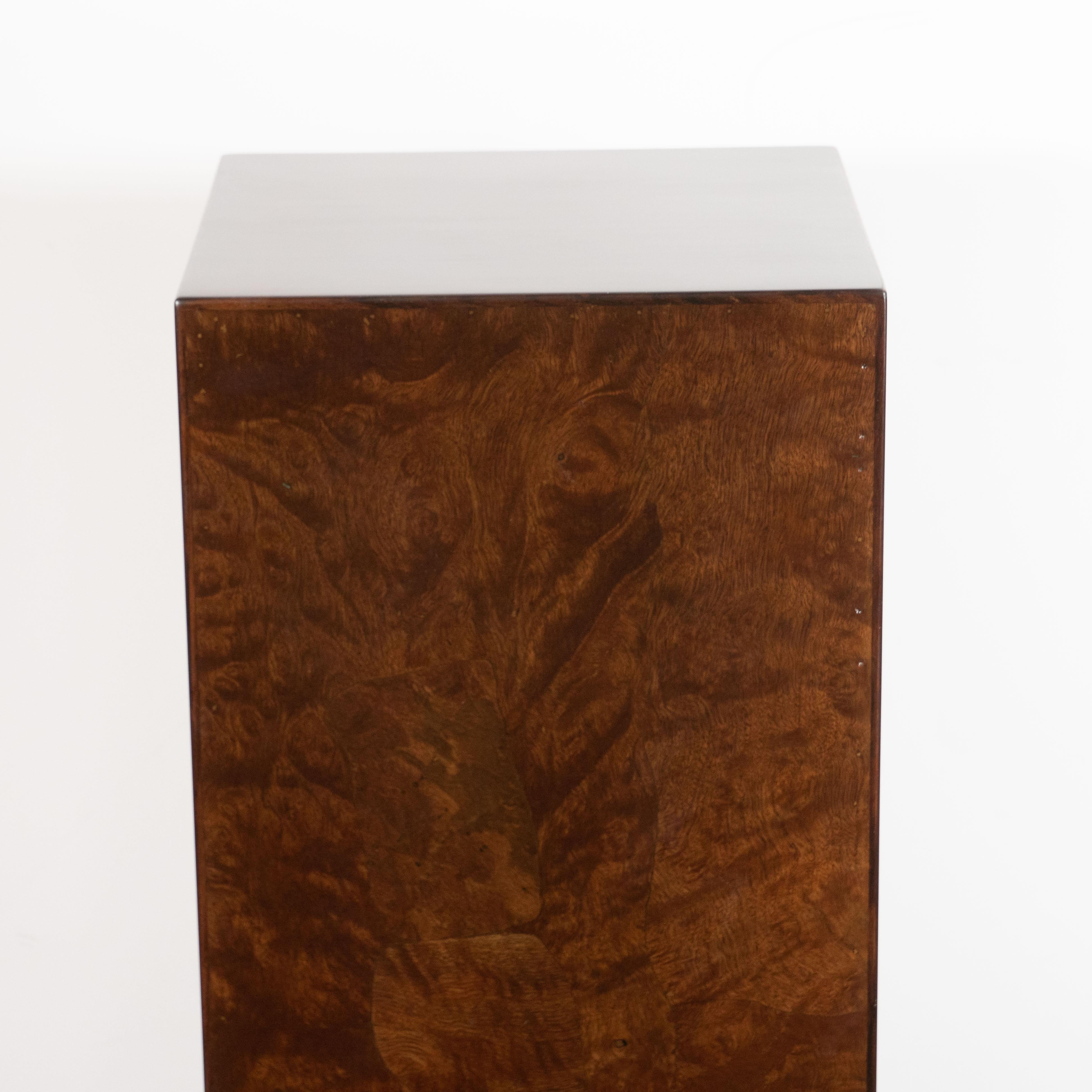 This refined pedestal was realized in the United States, circa 1970. It is composed of handrubbed burled walnut, which showcases the stunning natural grain of the hardwood. Its austere rectangular form and understated natural beauty ensures that it