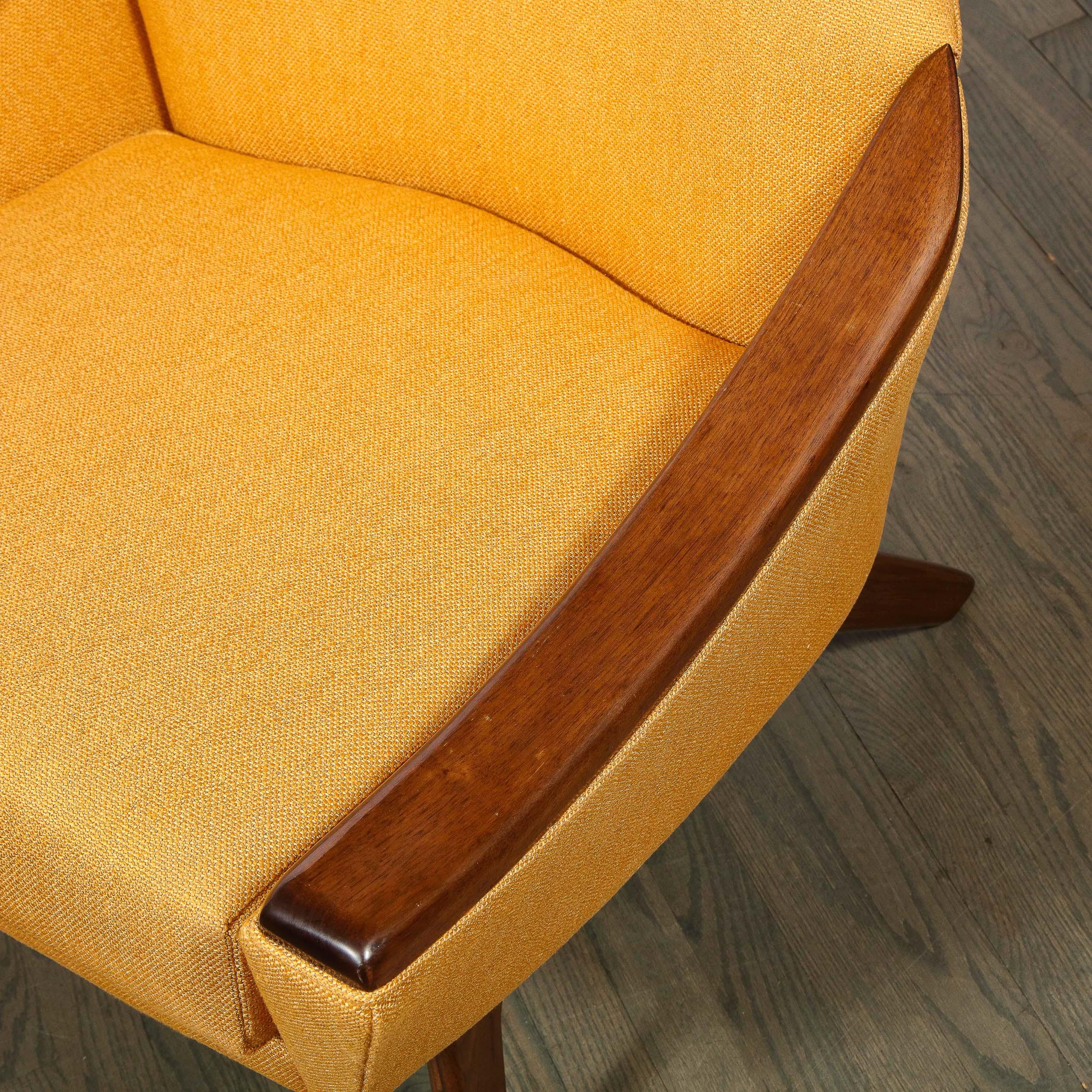 This elegant Mid-Century Modern arm chair was realized by the celebrated designer Adrian Pearsall circa 1960. It features button back detailing; concave arms; arched hind legs; and a sculptural apron all in hand rubbed walnut. With its dynamic form