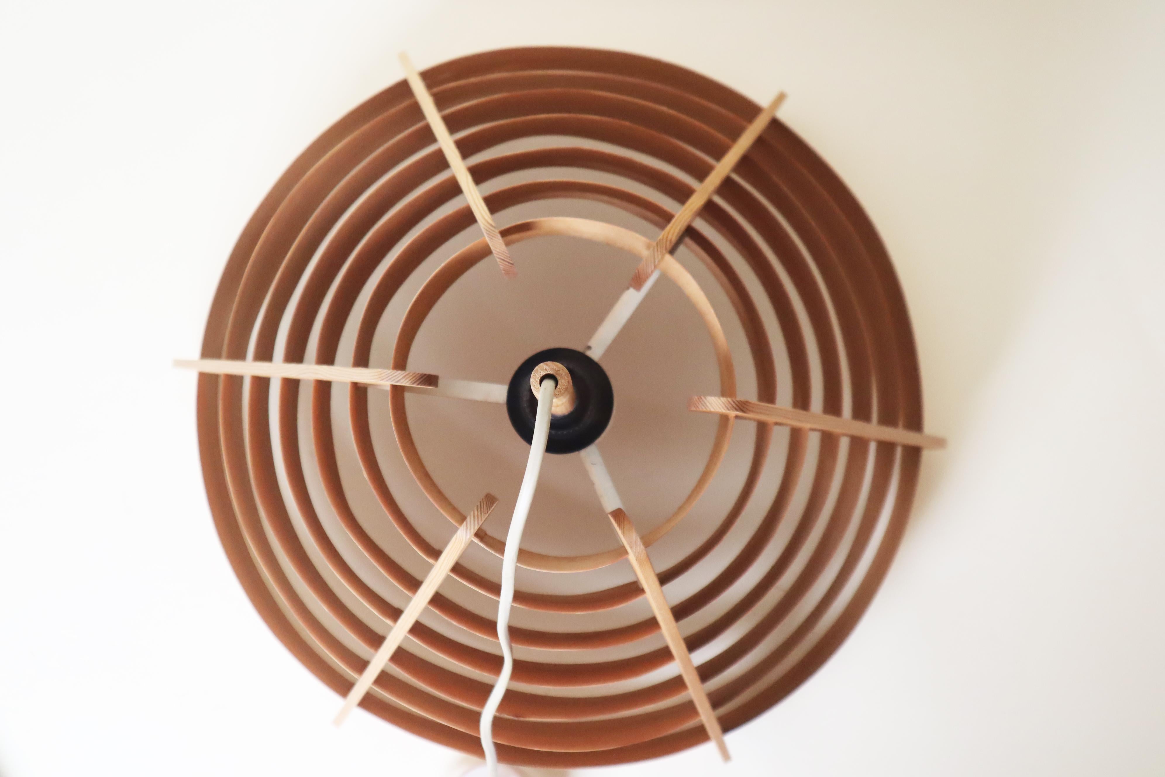 Je suis ravie de vous présenter cette magnifique lampe à cône en bois de pin ! La lampe est en très bon état et bien entretenue. Il y a quelques signes d'usure minimes et un minuscule défaut, mais c'est tout à fait normal pour cette lampe en raison