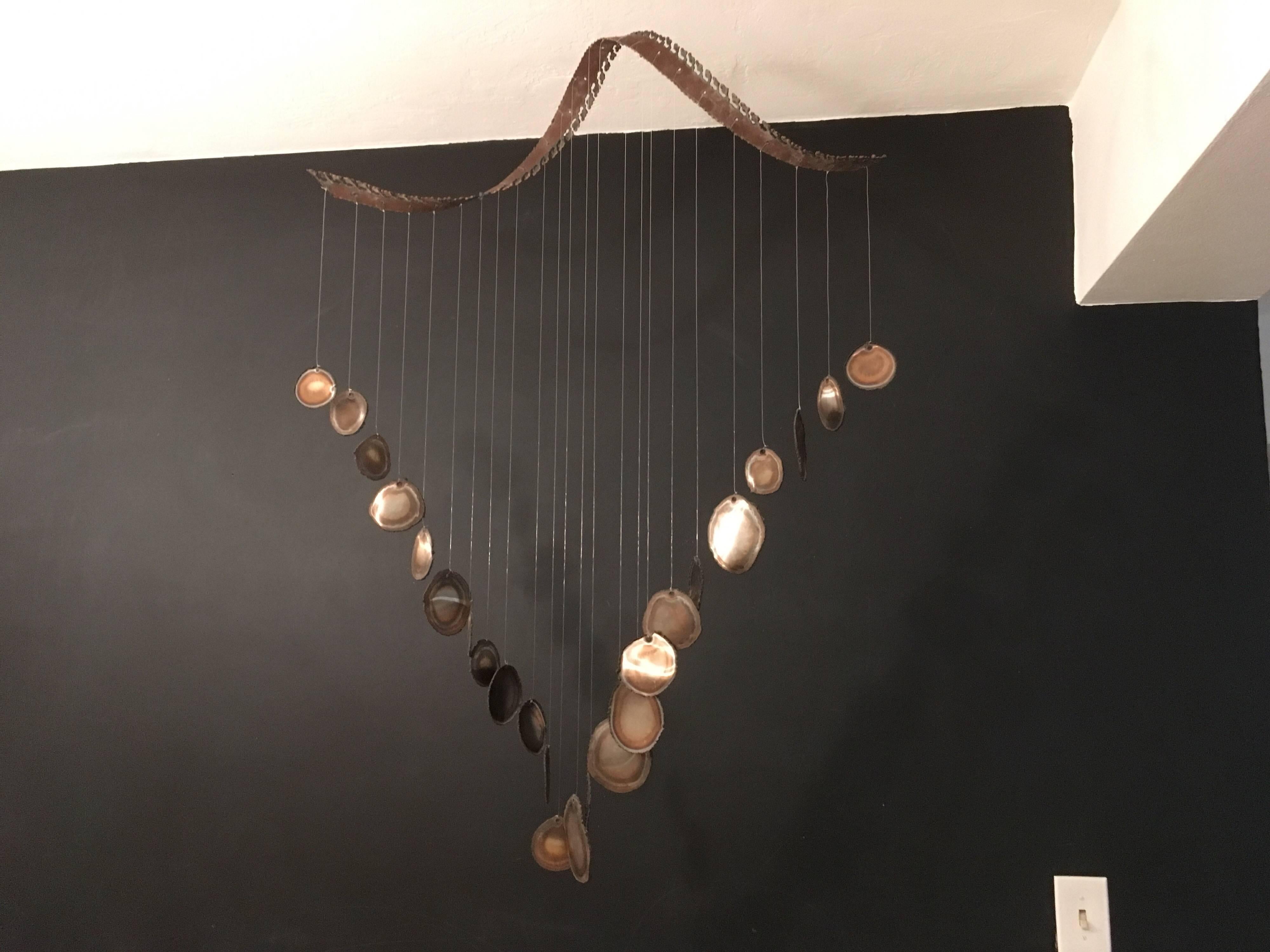 Twenty-four discs hanging from a spiral, true midcentury sculpture.