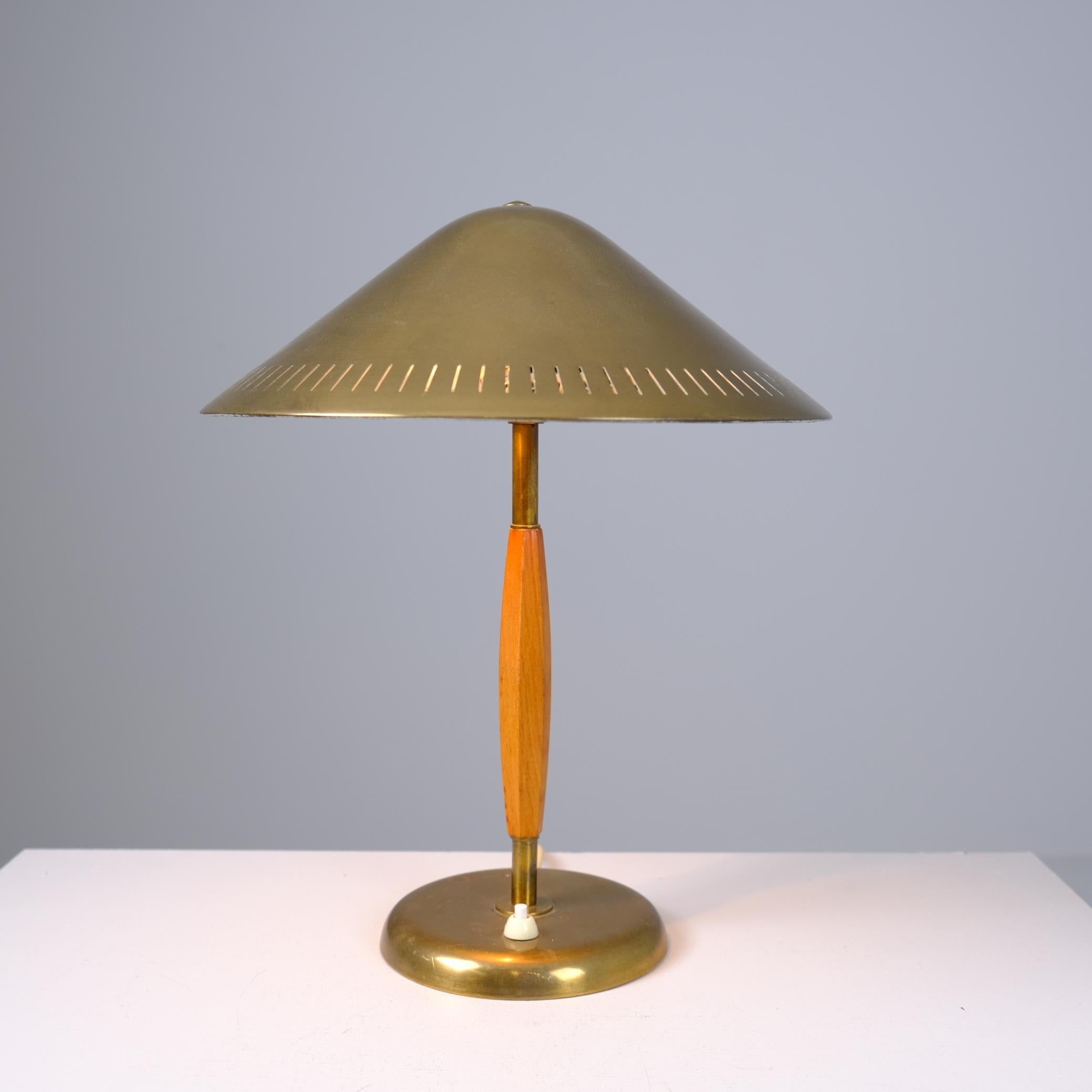 Une belle lampe de table avec une patine magnifique. Cette lampe de table moderne du milieu du siècle modèle 15296 par Harald Notini est faite de laiton et de bois et reste dans son état d'origine. La surface du laiton a développé une patine riche