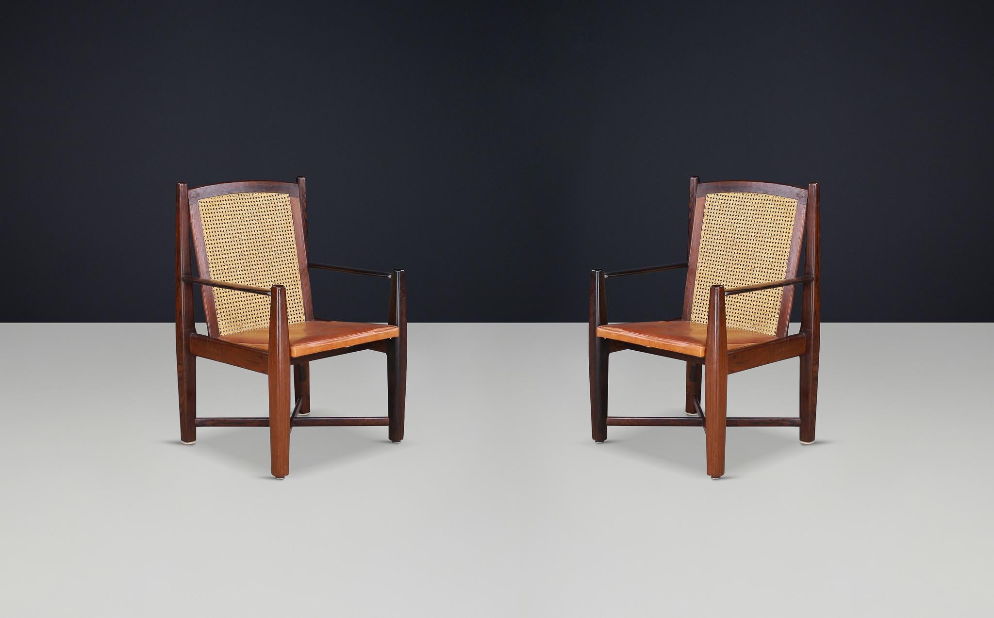 Mid-Century Modern Hardwood, Cane, and Leather Armchairs, Brazil 1960s

These Mid-Century Modern large armchairs are from Brazil, dating back to the 1960s. Expertly crafted from solid hardwood, this chair features a woven cane backrest that enhances