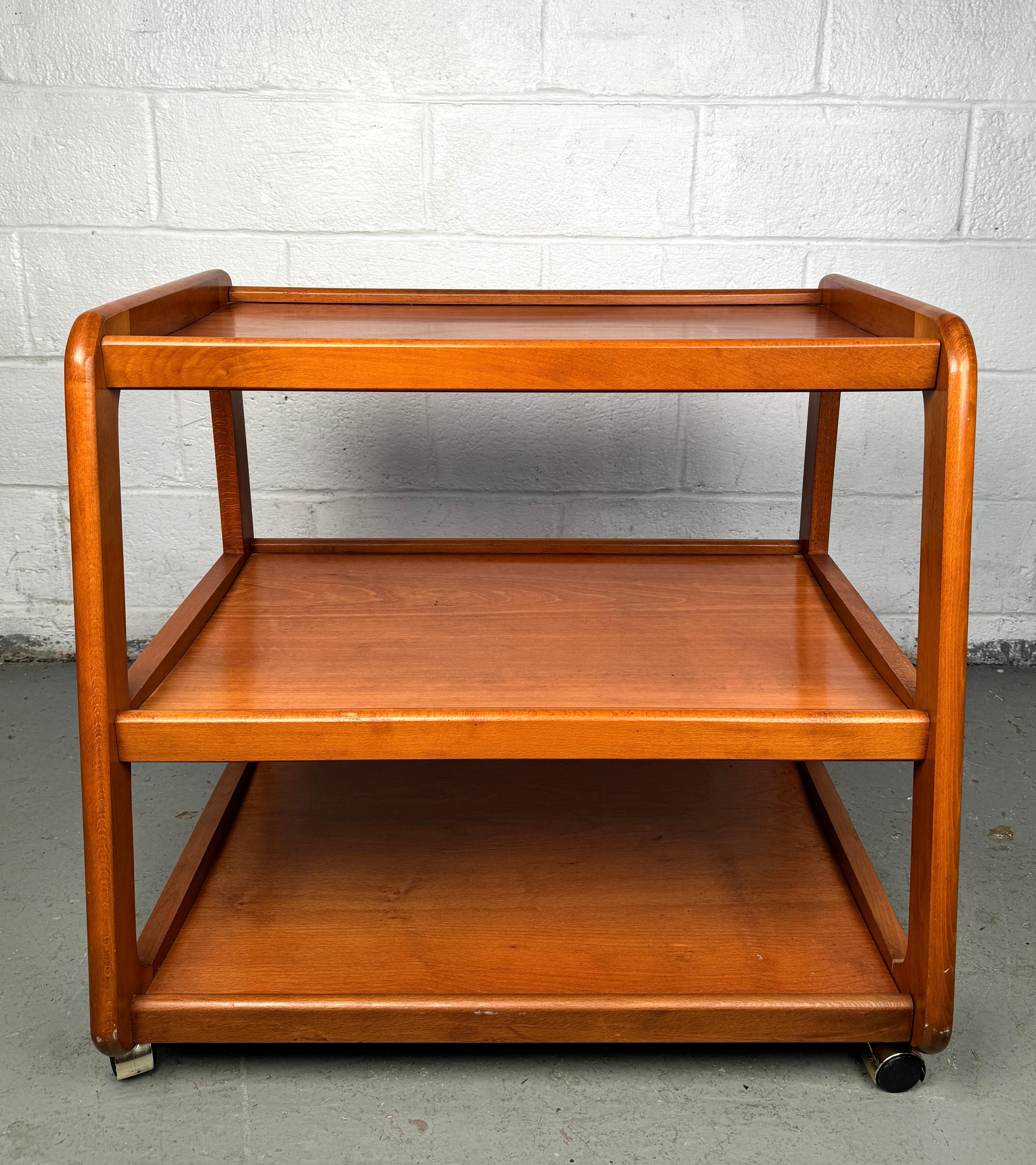 Servez avec style et sophistication grâce à ce chariot de service en bois dur moderne du milieu du siècle, fabriqué de manière experte en Roumanie. Conçu avec des lignes épurées et une esthétique élégante d'inspiration rétro, ce chariot est le