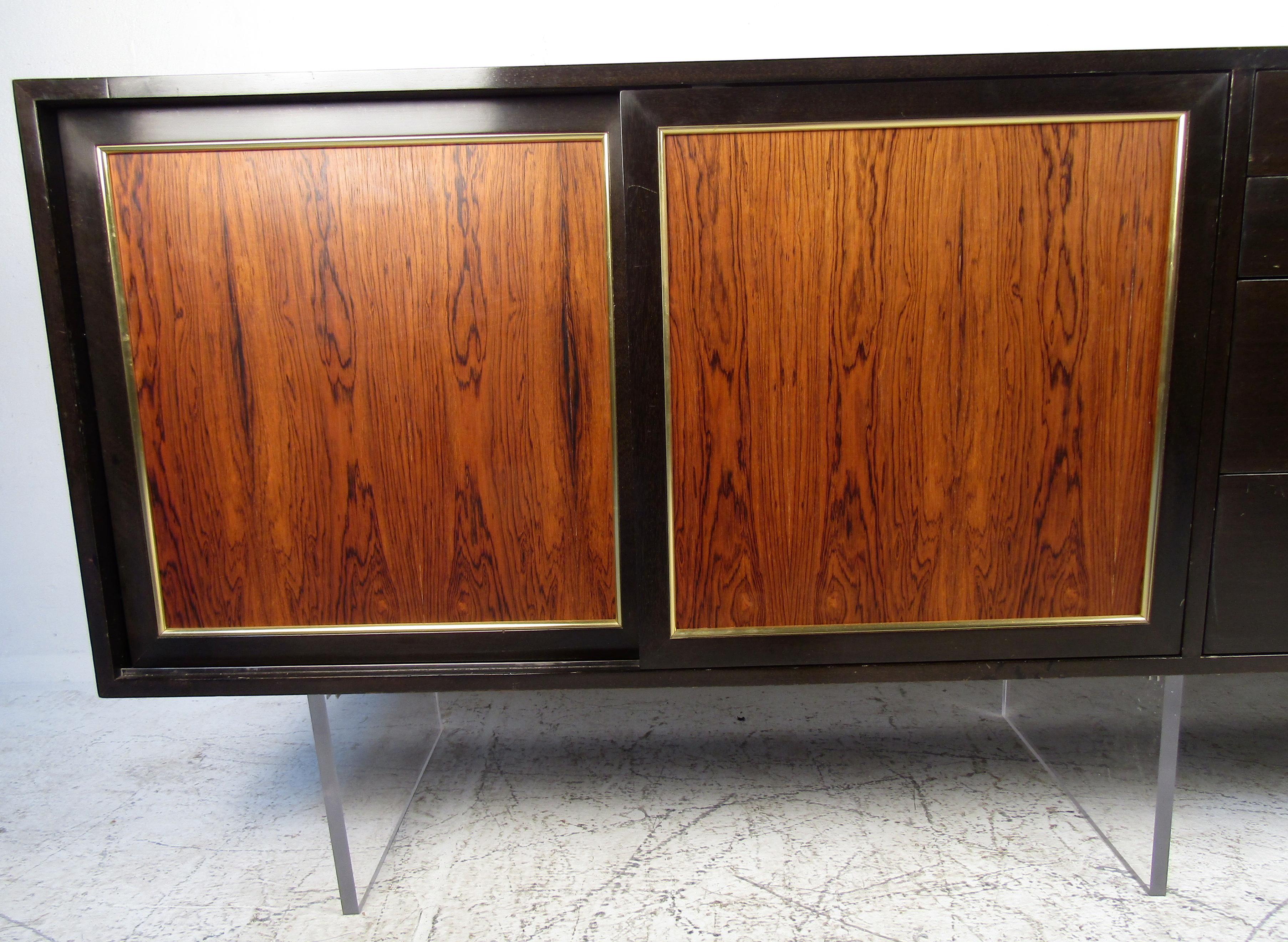 Vintage modern hutch featured in rich rosewood grain, Lucite base, four drawers, spacious storage space, and brass trimming. 

Please confirm the item location (NY or NJ).
 