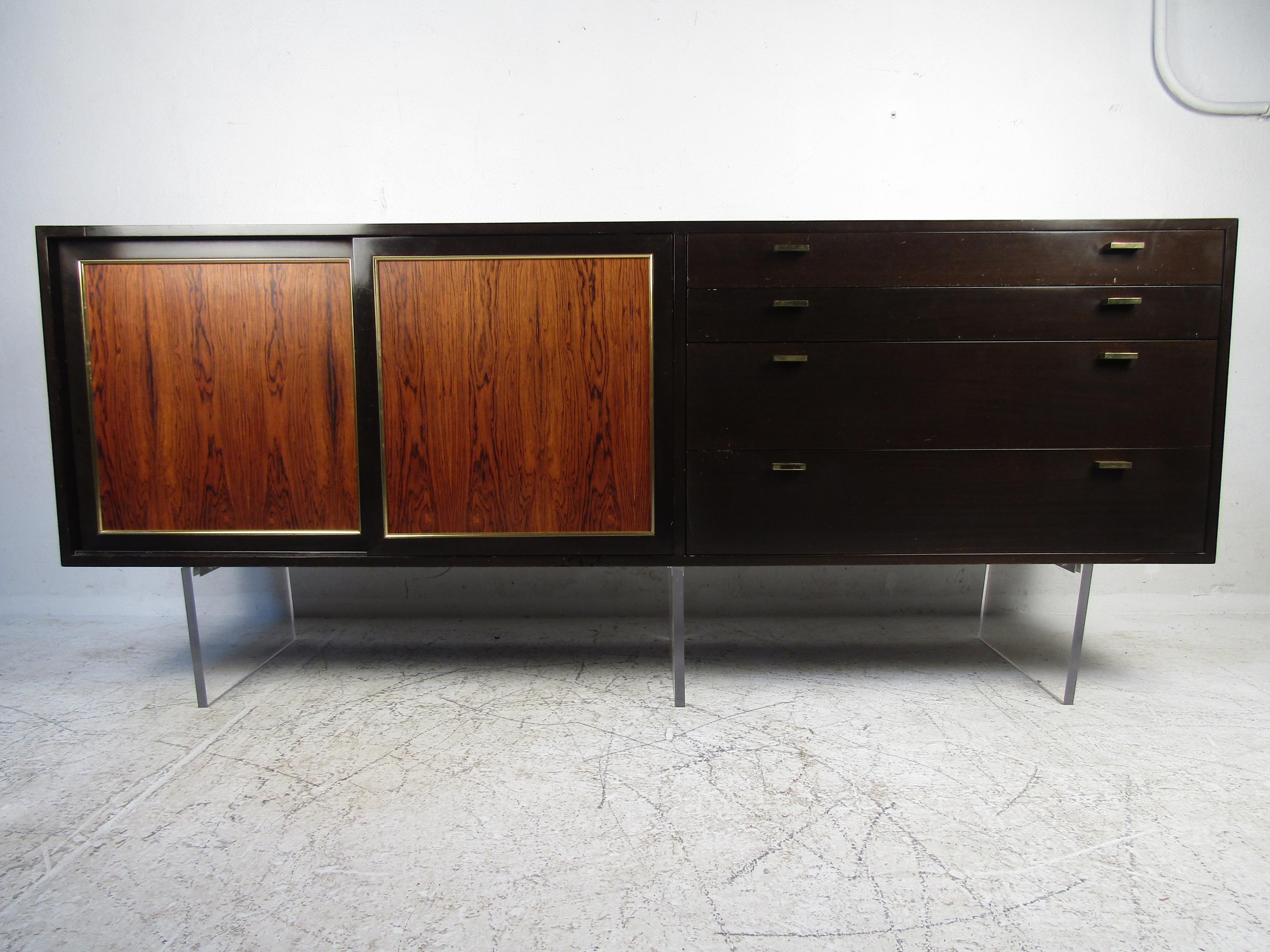 Vintage modern hutch featured in rich rosewood grain, Lucite base, four drawers, spacious storage space, and brass trimming. 

Please confirm the item location (NY or NJ).
 
