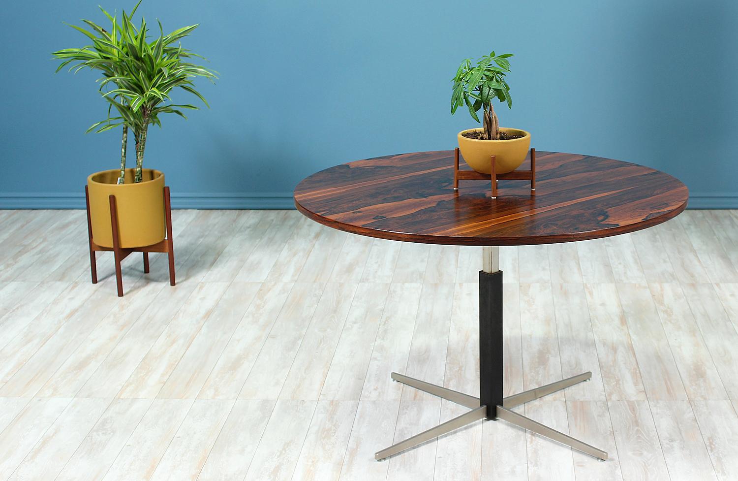 Adjustable table designed and manufactured in the United States circa 1960’s. This exclusive design features a magnificent rosewood top with an intricate grain pattern that shows symmetry and sits on a steel base. This height adjustable table