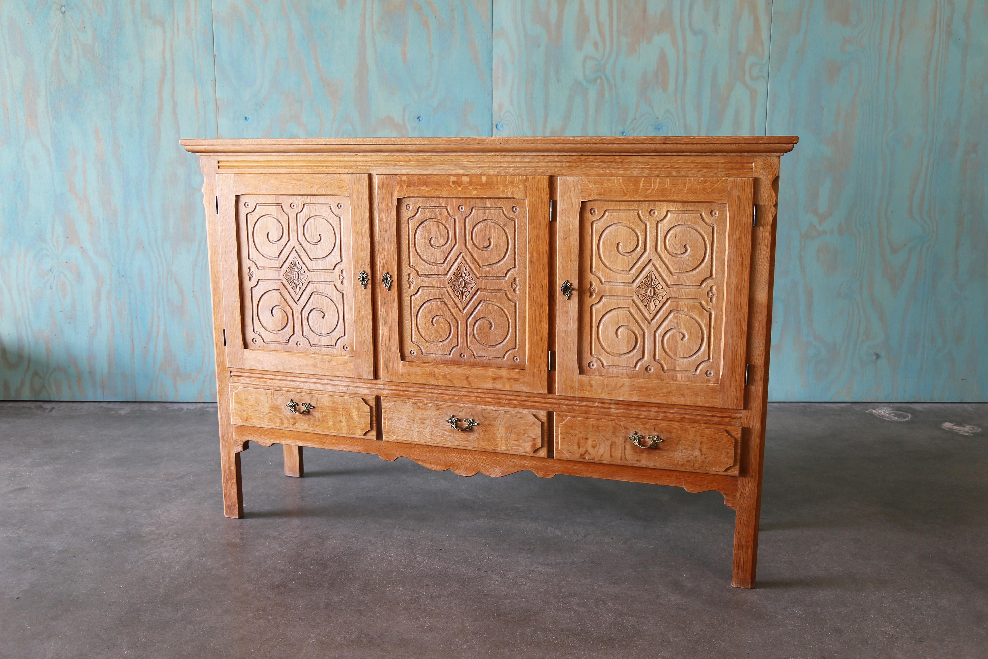 A monumental sideboard cabinet in the style of Henning Kjaernulf, made of solid quarter sawn oak, and oak veneer.  Plenty of storage, this piece can be used as an entertainment center, in a dining room or in an entryway for extra storage. Heavy