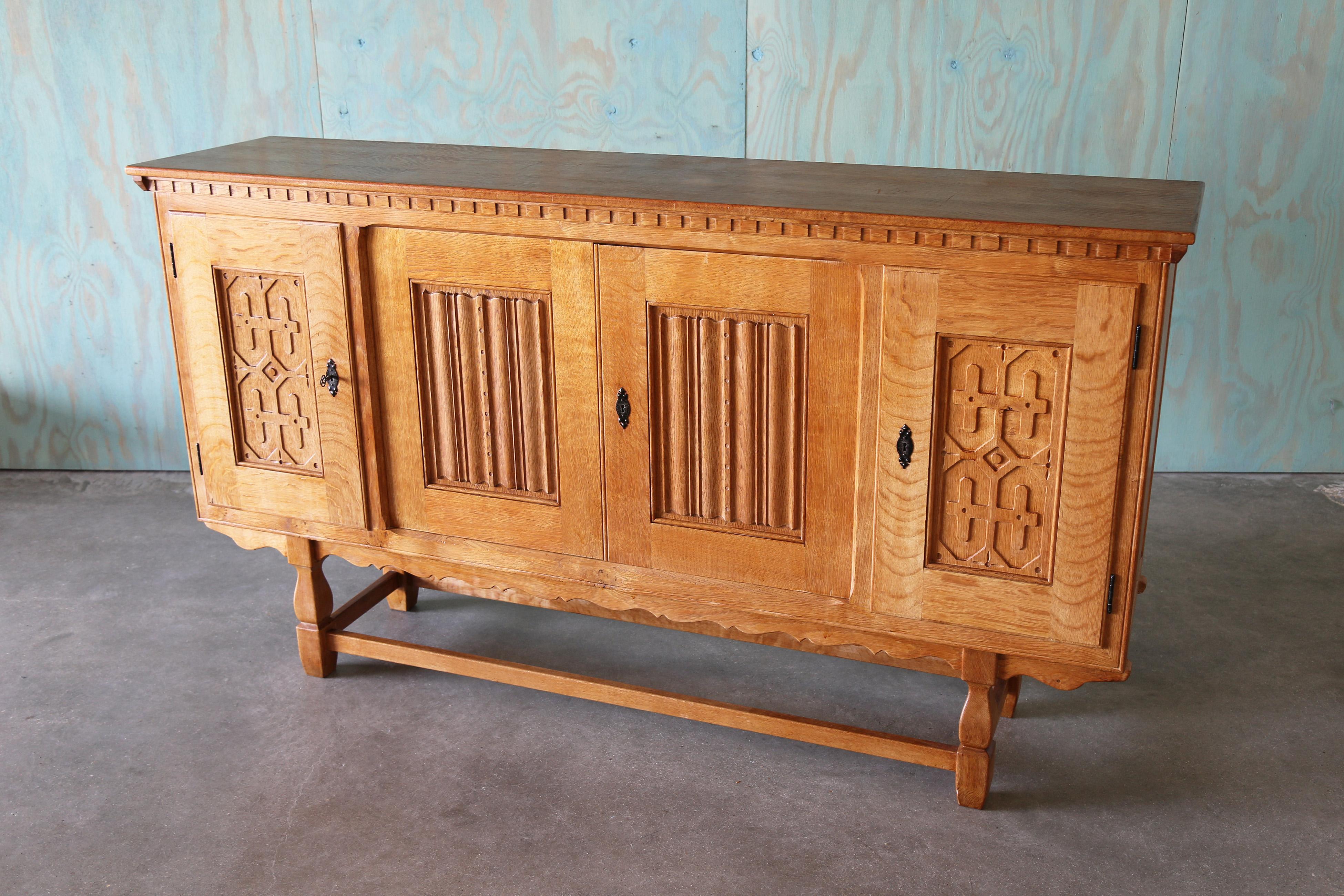 A monumental sideboard cabinet in the style of Henning Kjaernulf, made of solid quarter sawn oak, and oak veneer.  Plenty of storage, this piece can be used as an entertainment center, in a dining room or in an entryway for extra storage. Heavy
