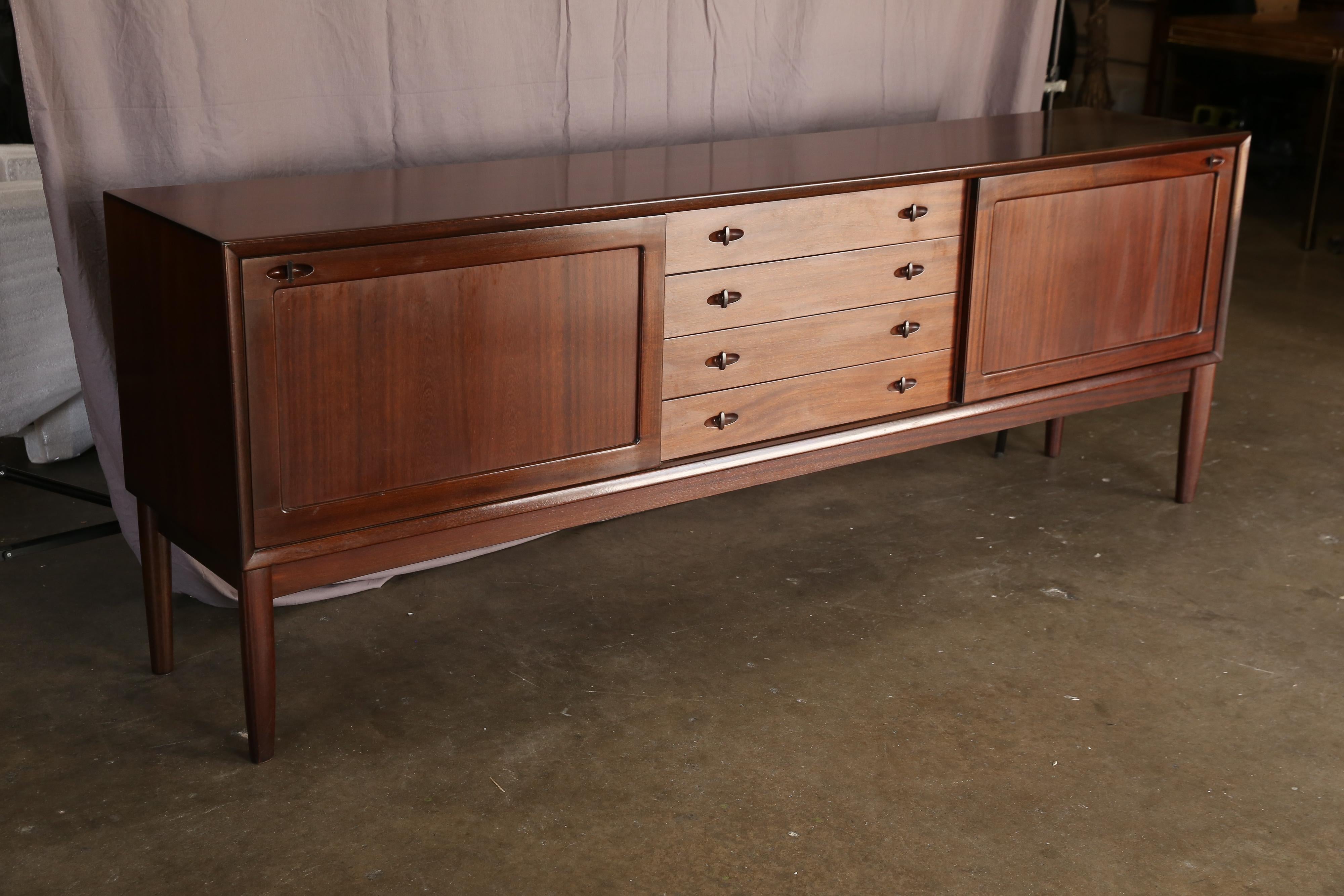 High quality mahogany sideboard. Designed by H. W. Klein for Bramin. Front with four drawers and two sliding doors. Behind sliding doors with shelves. Produced by Bramin Denmark. Note the beautiful organic shape of the legs and the straight lines of