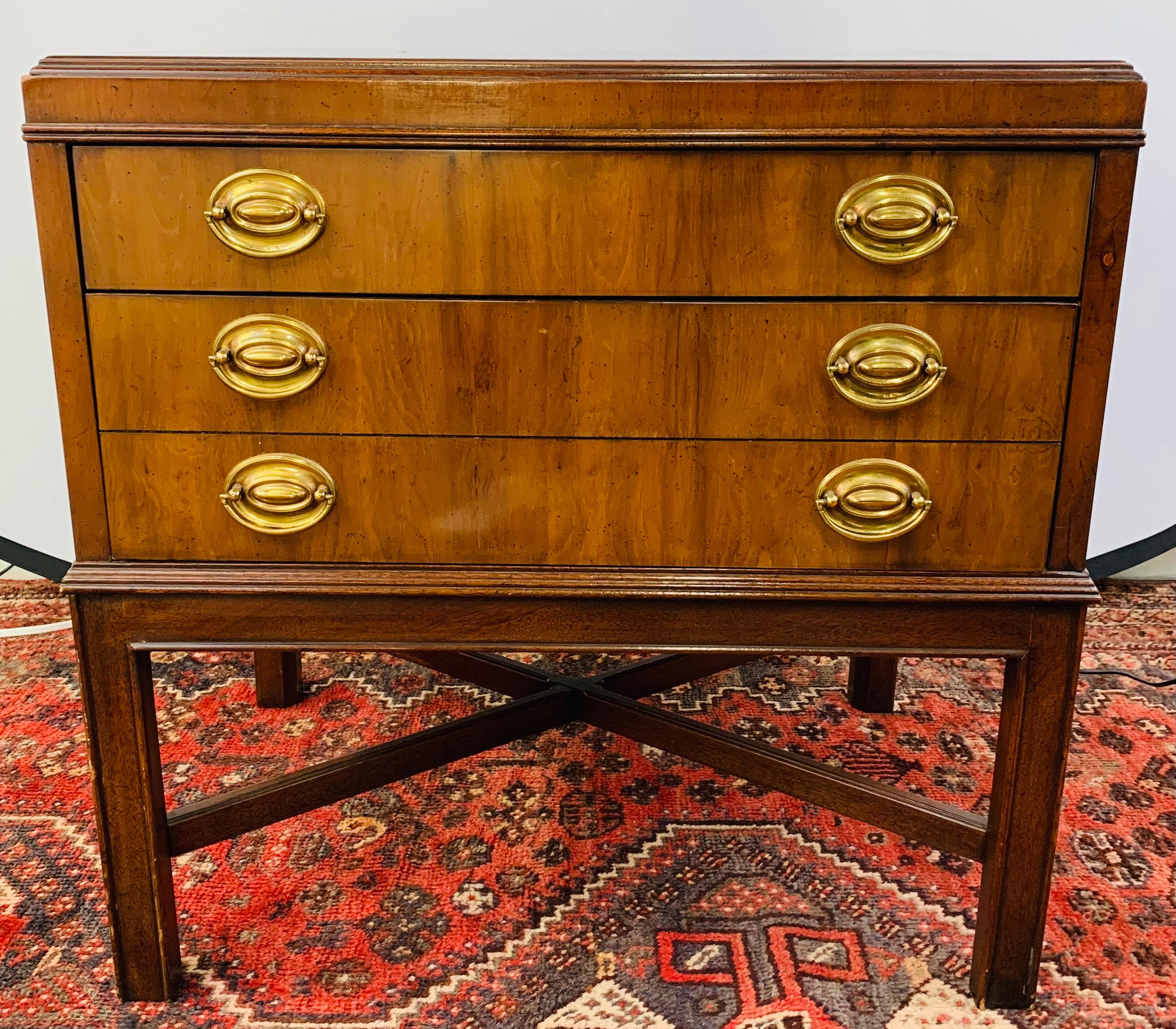 Une superbe commode, table d'appoint ou table de nuit simple, de style moderne du milieu du siècle, conçue par le grand designer de meubles américain Heritage. La commode est finement travaillée en bois de ronce de noyer plaqué, présentant de