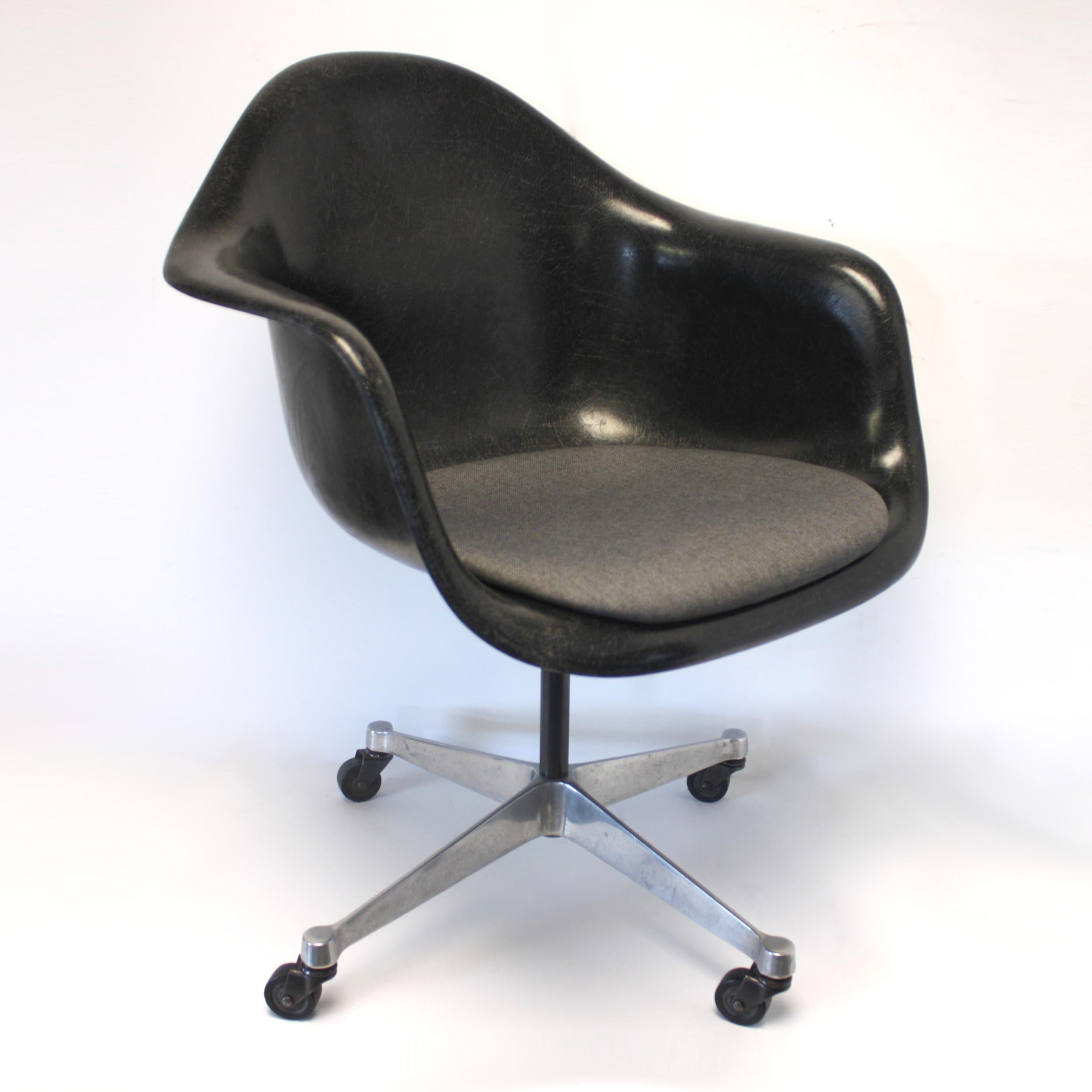 Original 1970s Herman Miller rolling desk chair. Chair features black fiberglass shell, polished aluminum rolling base, and brand-new, authentic Herman Miller seat cushion in Medley Charcoal fabric. Very comfy!

Chair arm height: 25.75