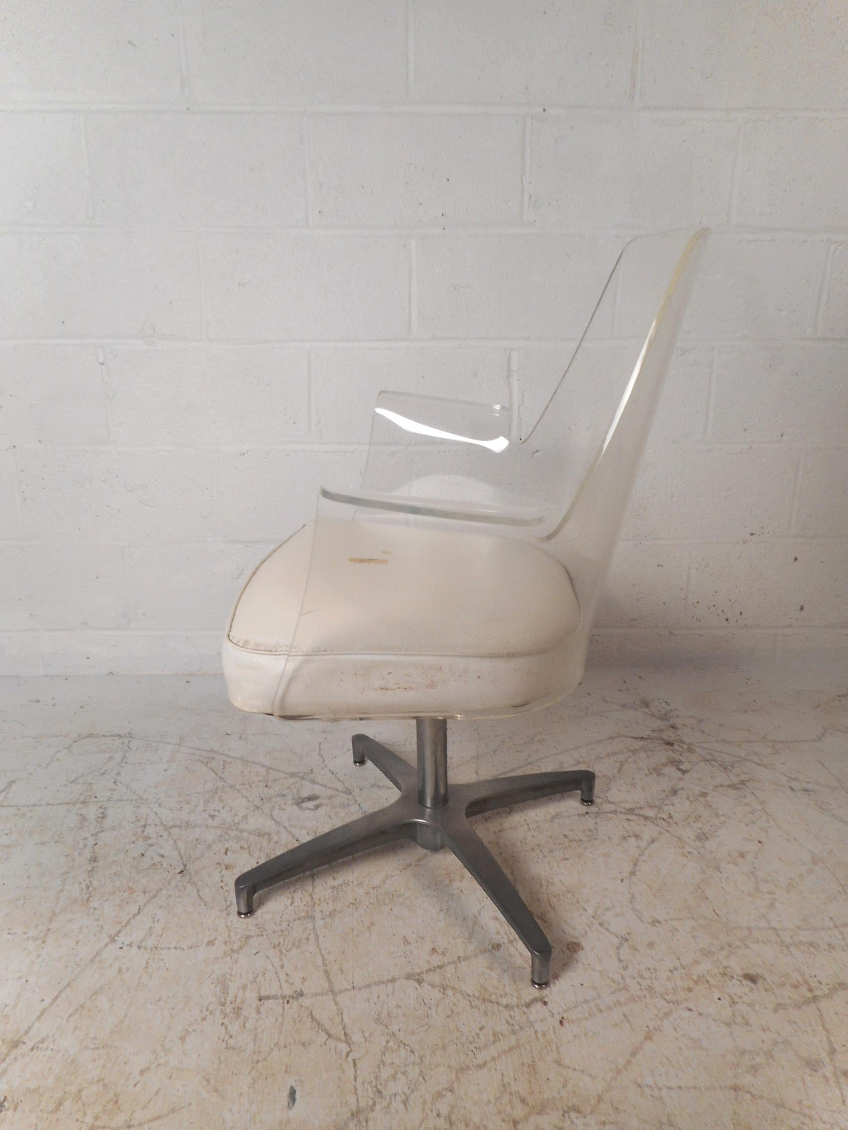 A beautiful vintage modern Lucite desk chair with turned armrests and a swivel base. The thick padded seating covered in white vinyl and sculpted design add to the midcentury appeal. This unique Herman Miller style chair offers maximum comfort