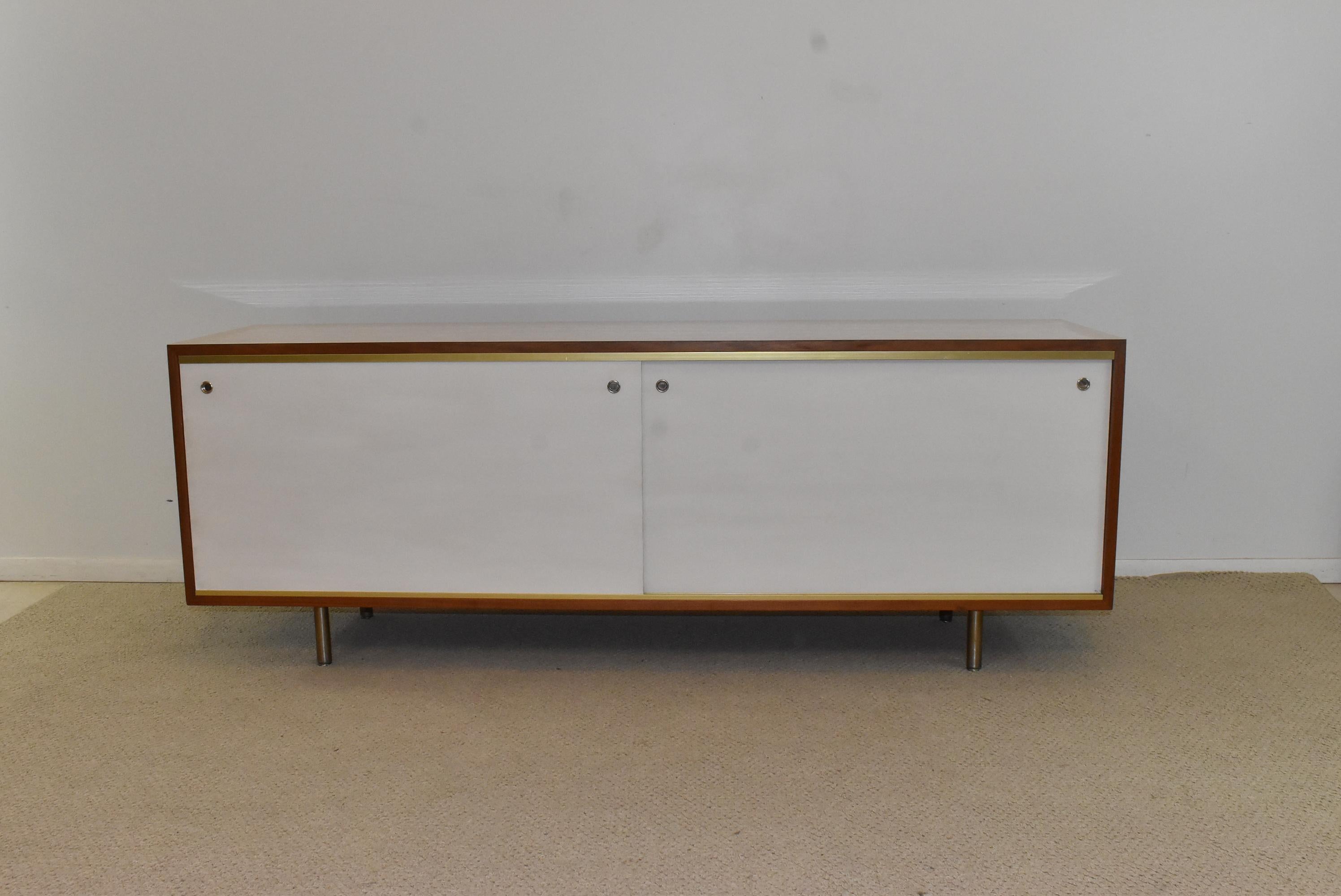 Mid-Century Modern Herman Miller walnut and laminate credenza designed by George Nelson. Round aluminum steel legs with adjustable levelers. Four removeable adjustable shelves. Finished back. Very nice to excellent condition. 70