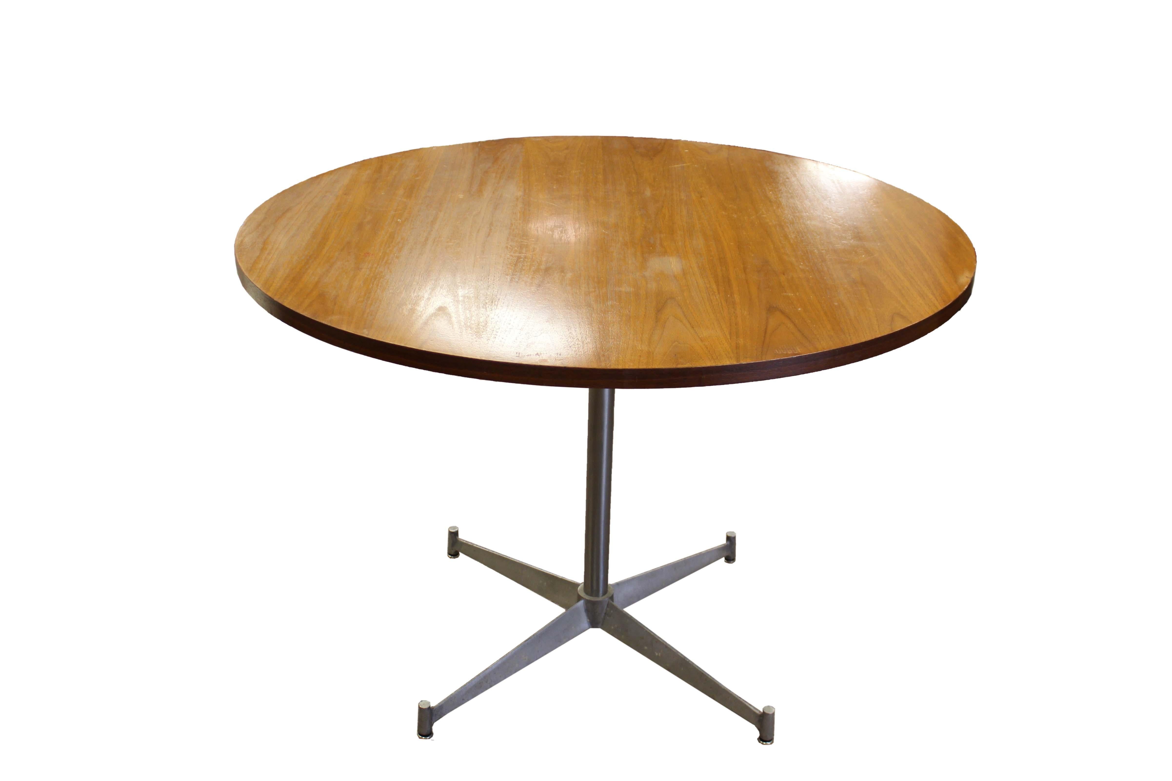 Le Shoppe Too presents an iconic Herman Miller dinette game table in walnut wood with a metal star base. In vintage condition. Dimensions: 42