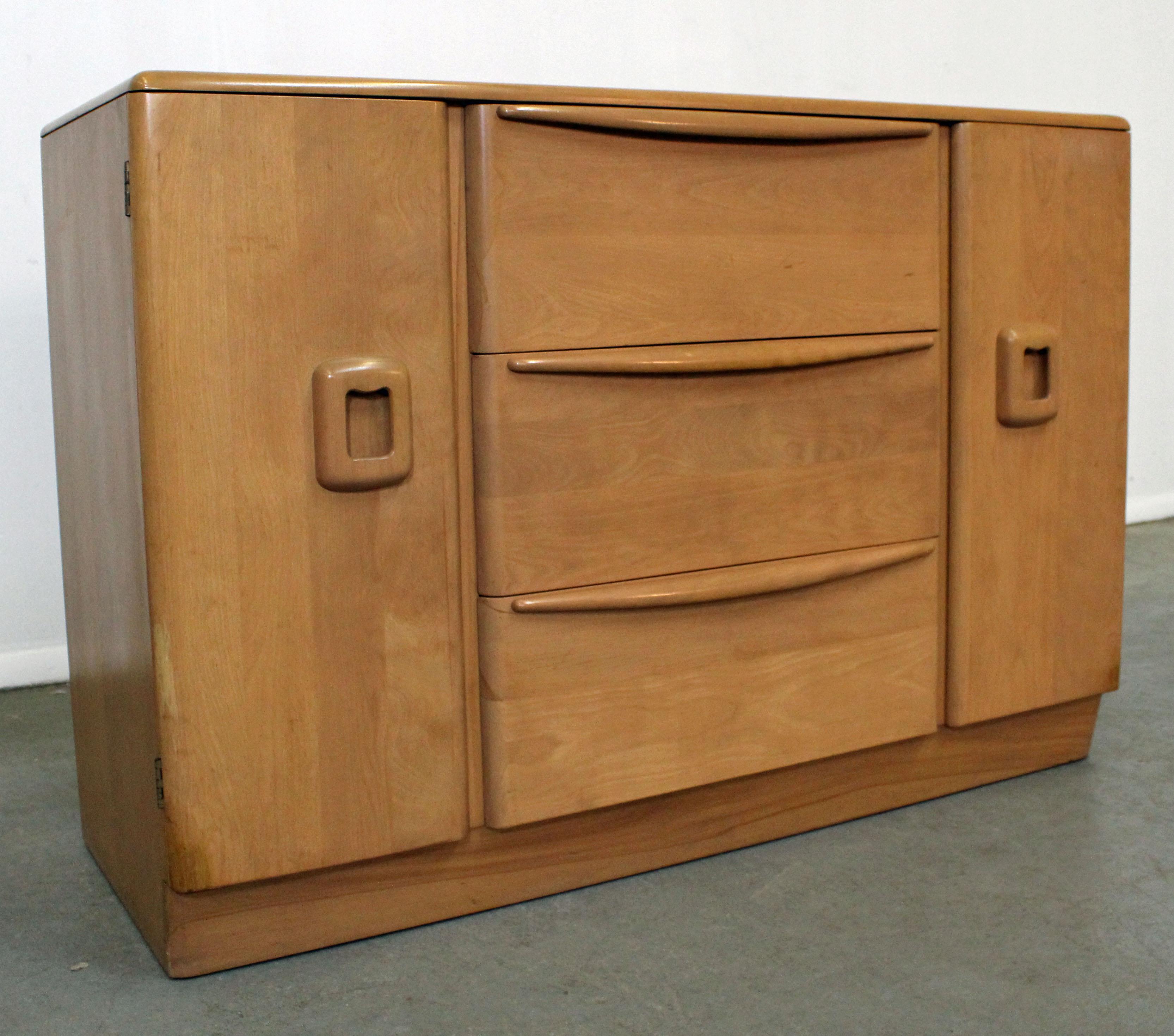 What a find. Offered is a mid-century credenza by Heywood Wakefield. It is made of birch with a 'Champagne' finish. Features a combination of three center drawers and two side doors with shelving. It is in good condition for its age, shows some