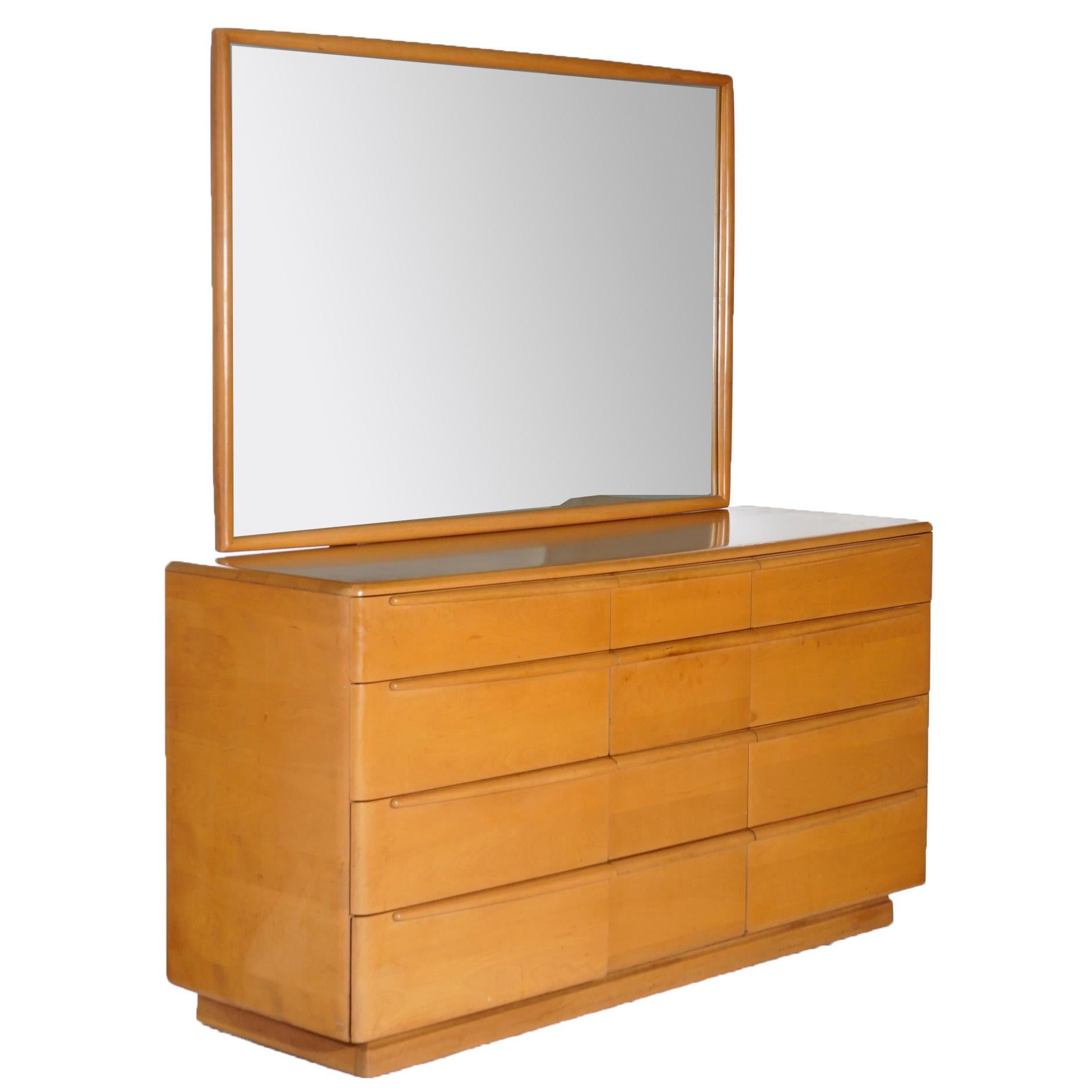 A Mid-Century Modern mirrored dresser by Heywood Wakefield offers birch construction with three four-tower drawers, Champagne finish, maker mark as photographed, c1950.

Measures- 68''H x 62.25''W x 20''D.