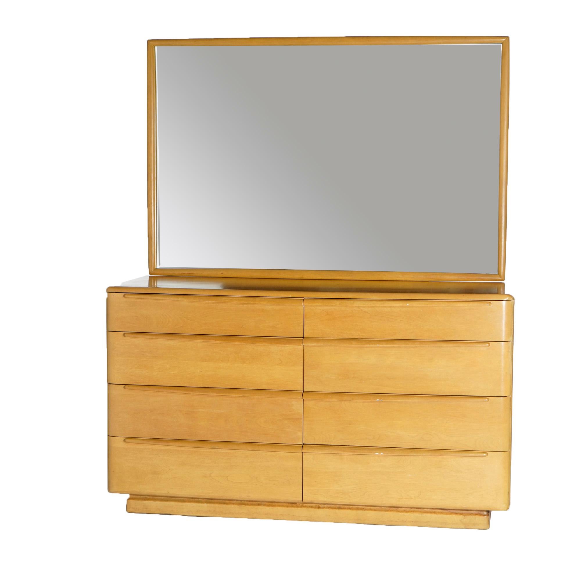 A Mid-Century Modern dresser by Heywood Wakefield offers birch construction with large mirror over eight- drawer chest, wheat finish, maker mark as photographed, c1950.

Measures- 68''H x 56.25''W x 20.5''D.

Catalogue Note: Ask about DISCOUNTED
