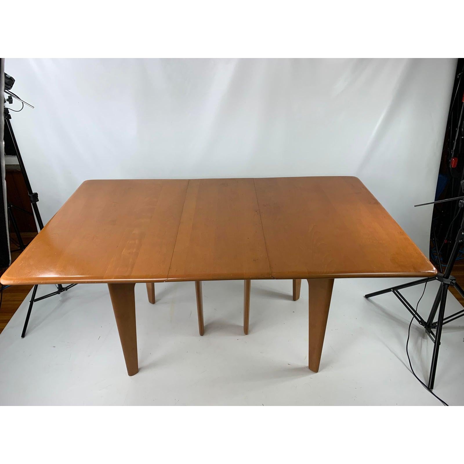 Mid-century Heywood Wakefield drop leaf dining table. Table is in classic champagne finish. Tables width when closed is 16”.