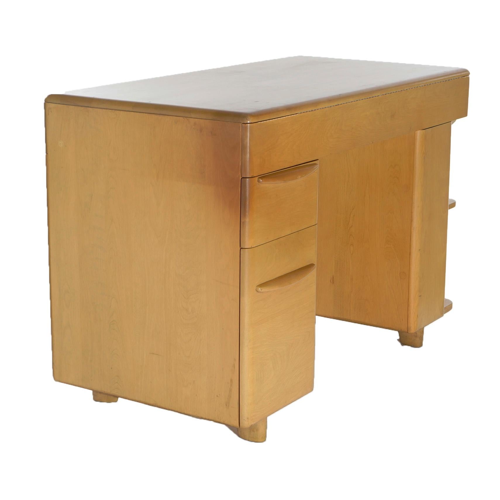 A Mid-Century Modern desk by Heywood Wakefield offers birch construction with frieze drawer over kneehole with flanking drawer tower and shelving tower, maker label as photographed, c1950

Measures- 30.25''H x 44''W x 22.75''D.

*Ask about