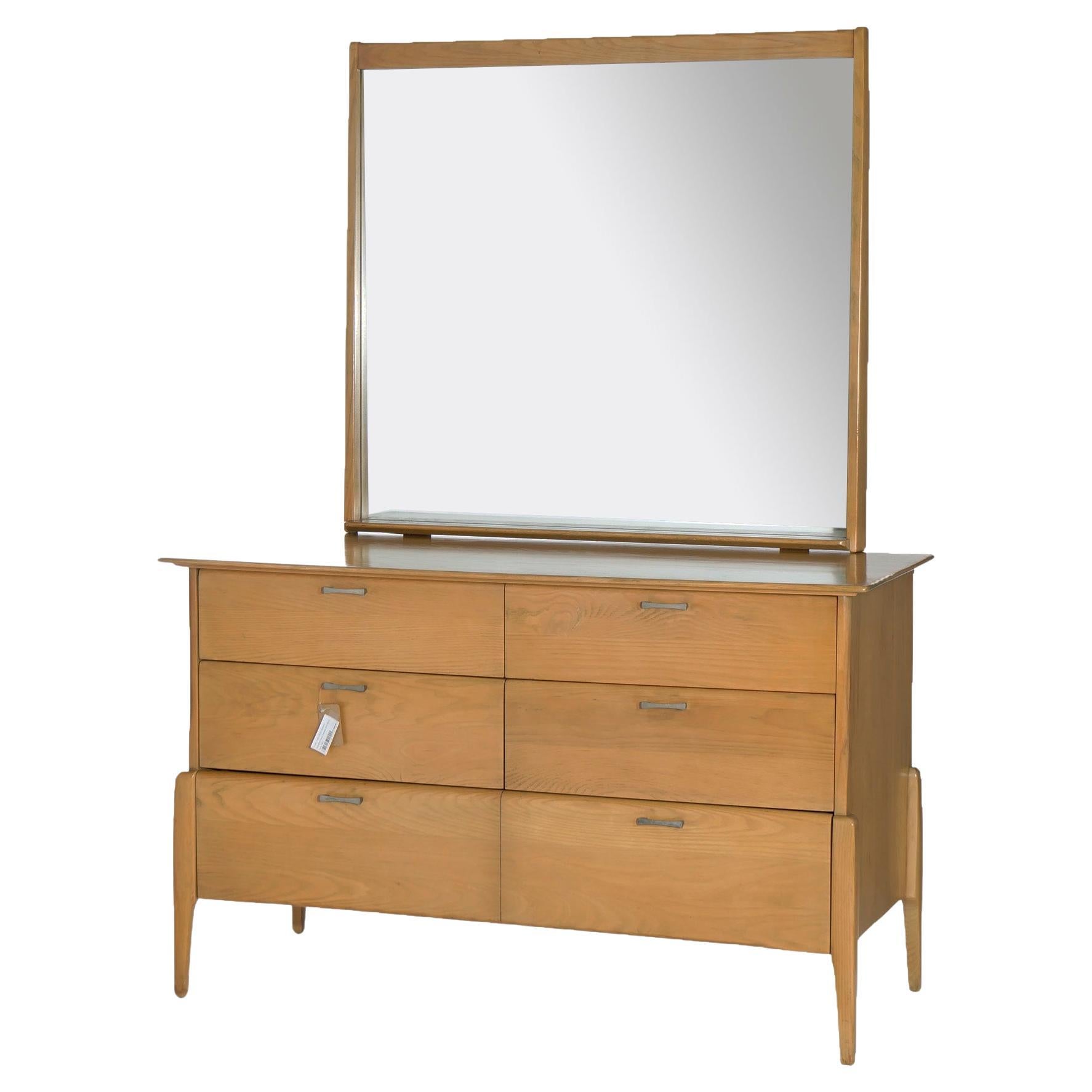 A Mid-Century Modern mirrored chest of drawers by Heywood Wakefield of the Prophecy collection offers four drawers over lower divided drawer, raised on tapered legs, Fawn finish, maker mark as photographed, c1950.

Measures- 67.75'' H x 48.75'' W