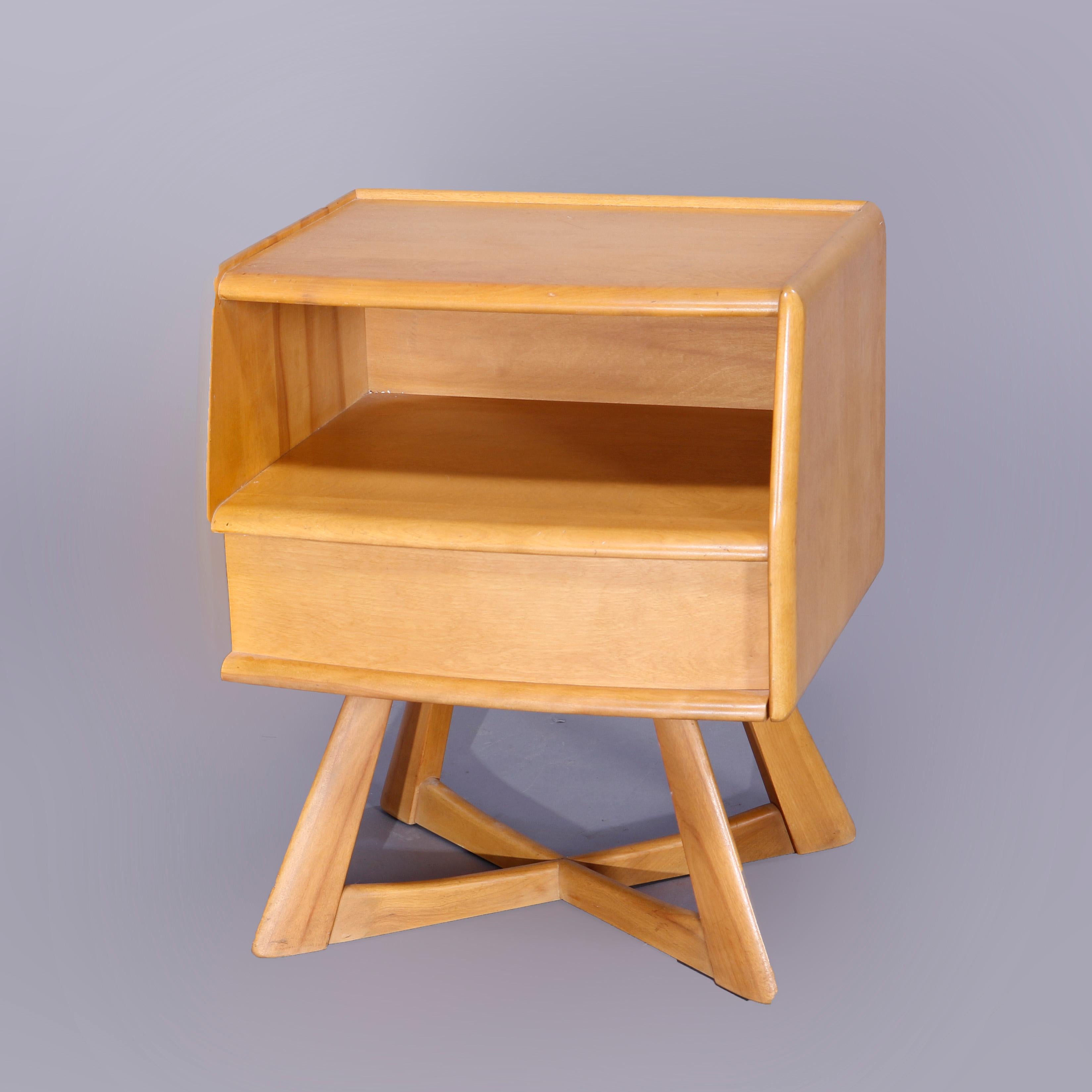 A Mid-Century Modern Heywood Wakefield side stand in the Sculptura pattern offers birch construction with case having open shelf over single drawer, raised on geometric open legs, Wheat finish, c1950

Measures- 24'' H x 20'' W x 16.5'' D.